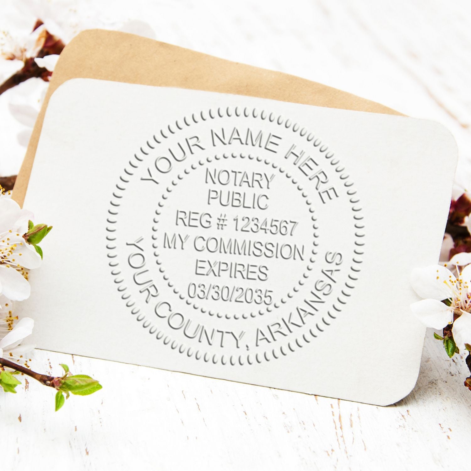 White embossed notary public seal stamp on a tan envelope, with floral accents and rounded card.