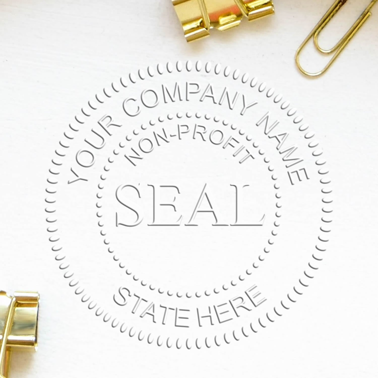White embossing stamp seal design with gray circular company text and gold binder clips on a clean white background.