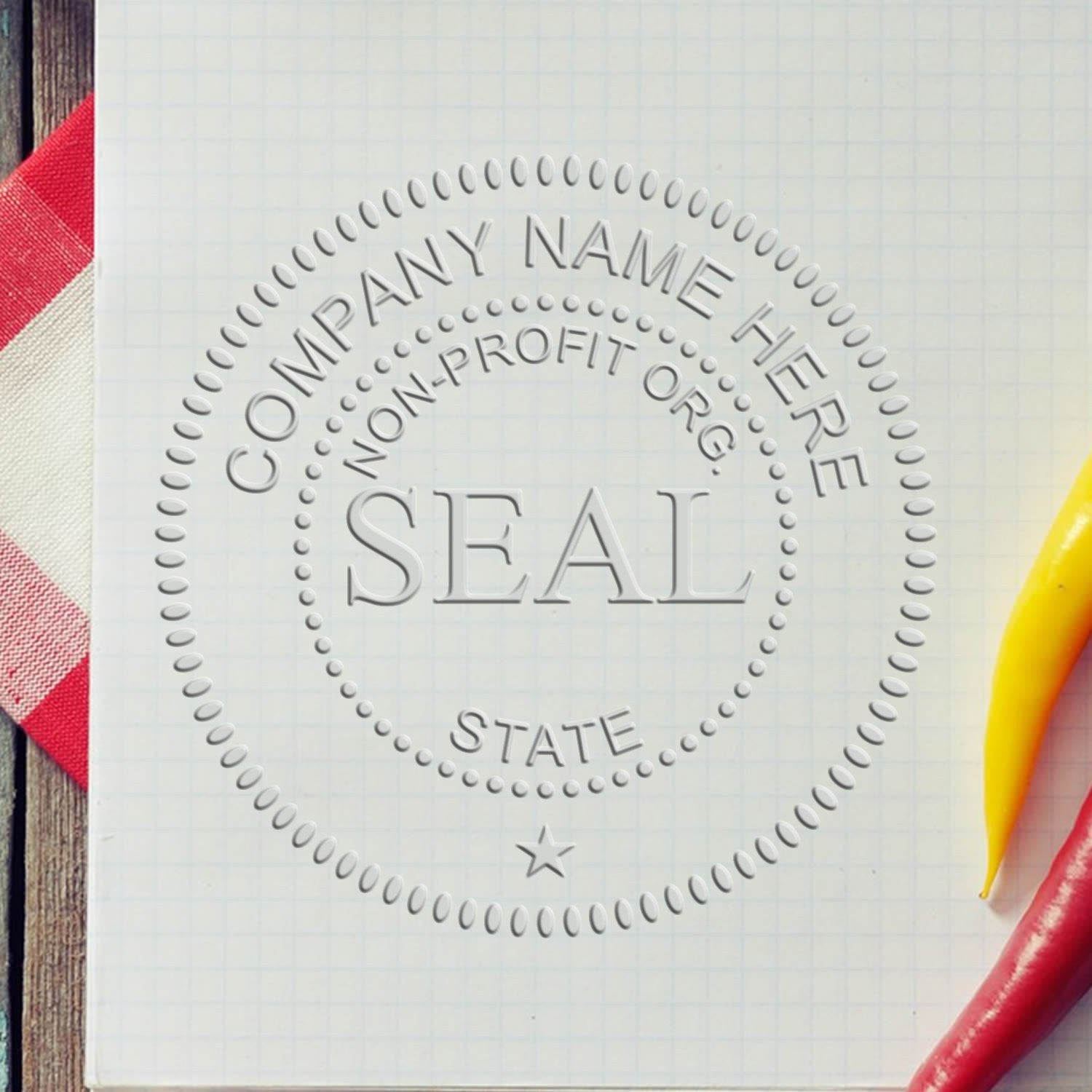 Gray embossed company seal stamp template on white grid paper, with dotted circles, star, and red and yellow pens.
