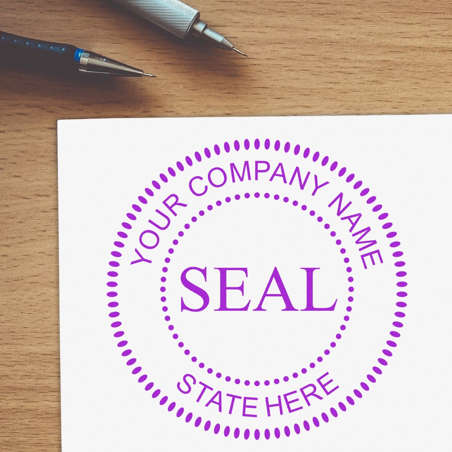 Purple customizable company seal stamp on white paper, with dotted circle design and pens on a wood desk.