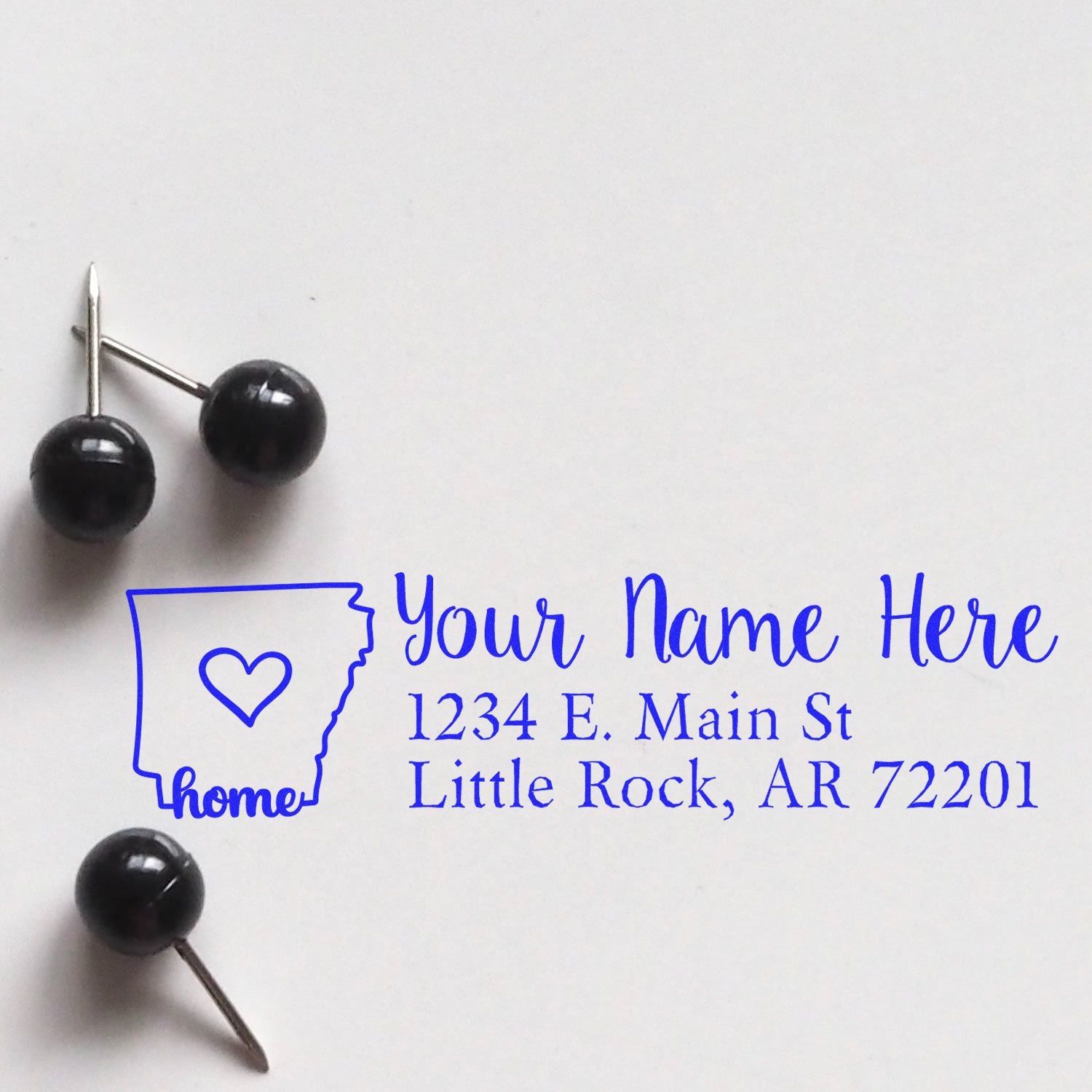 Wood handle Arkansas state address rubber stamp from ESS, featuring custom design in use with clear state and address details.