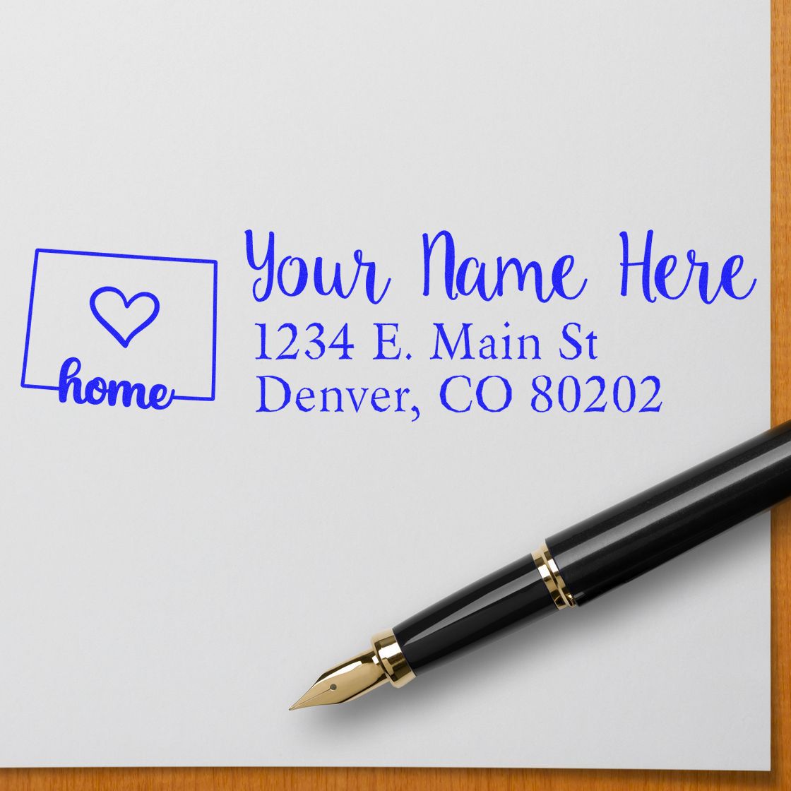 Wood handle Colorado state rubber stamp from ESS featuring custom address design in use on paper.