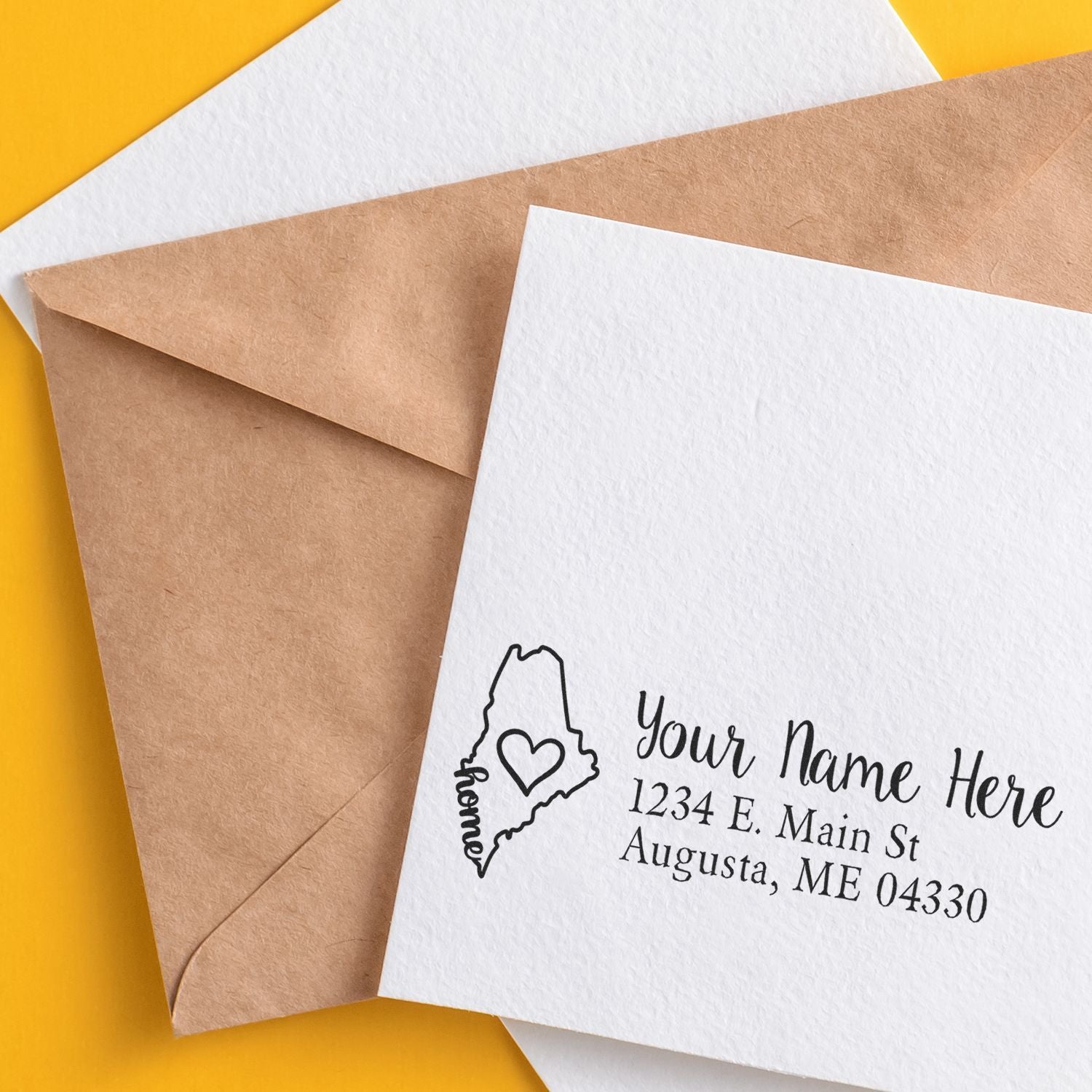 Maine custom address rubber stamp with wood handle from ESS, featuring a state love design in use on paper.