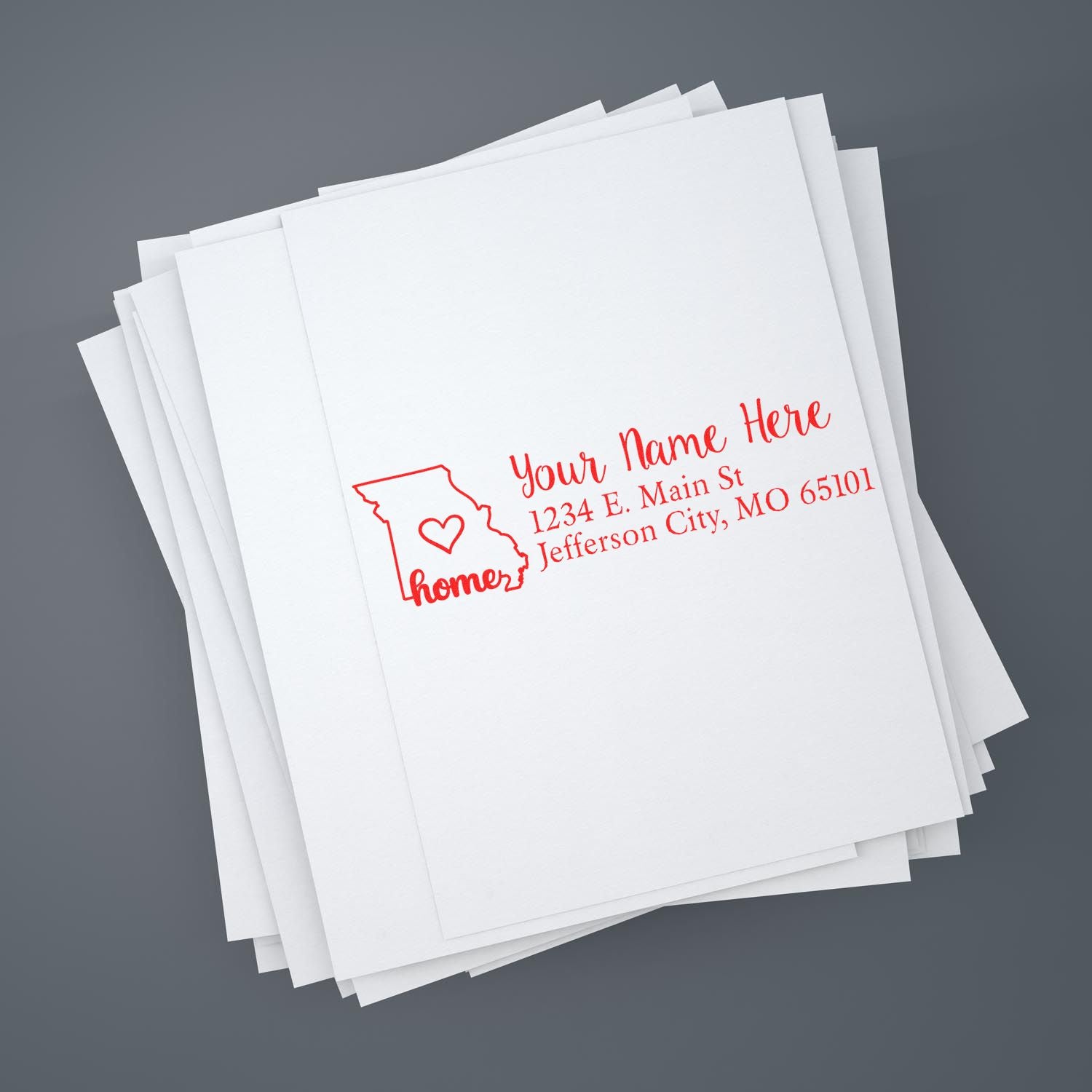 Wood handle Missouri state rubber stamp with custom address design by ESS, in use on paper.