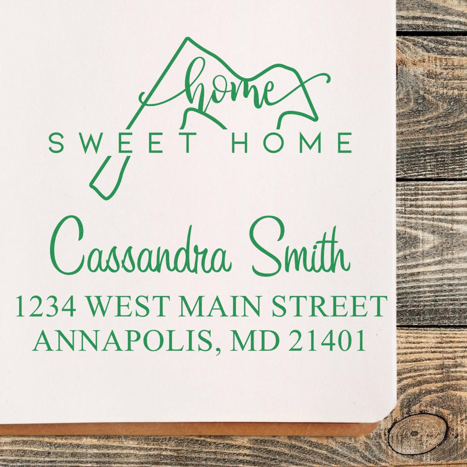 Green custom address stamp seal with home sweet home, Cassandra Smith, and Annapolis, MD address on white paper.