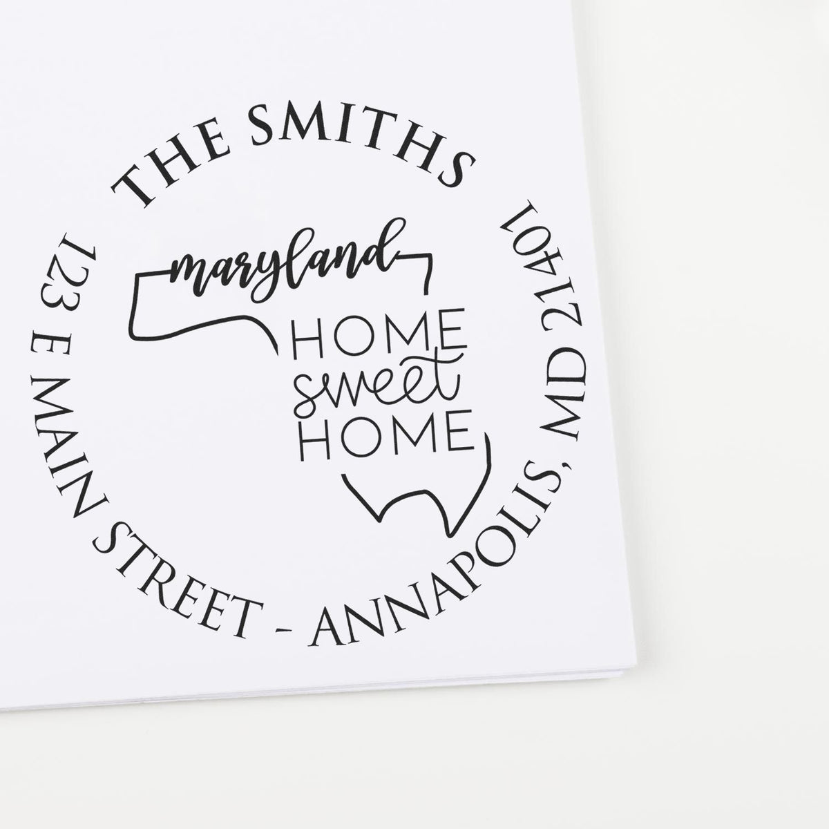 Black custom stamp seal with Maryland outline, home sweet home text, and The Smiths address on white paper.