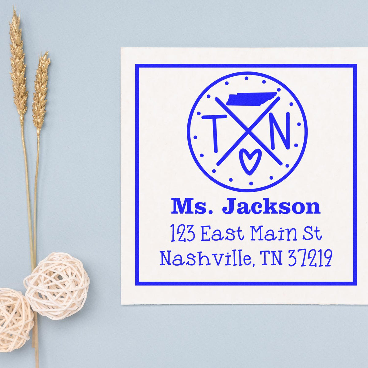 Blue personalized address stamp and seal with Ms. Jackson, Nashville address, circular monogram and heart on white.
