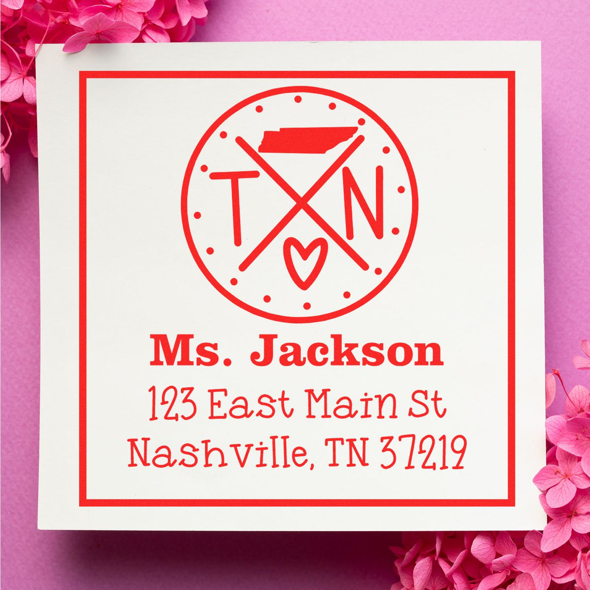 Red personalized stamp and seal for Ms. Jackson with Nashville address on a white card, surrounded by pink flowers.