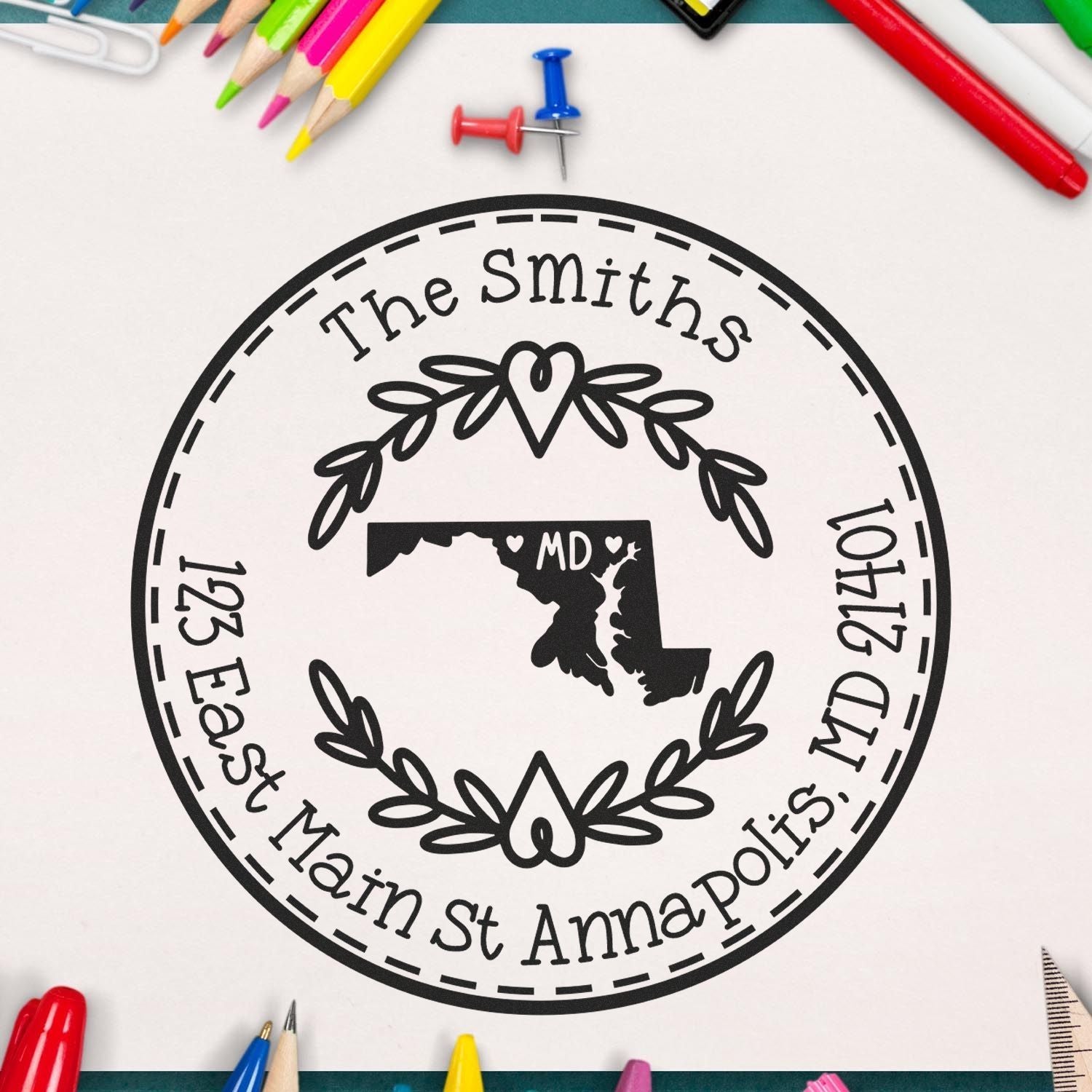 Custom black circular address stamp and seal with Maryland outline, The Smiths, Annapolis address, surrounded by colorful pencils and pins.