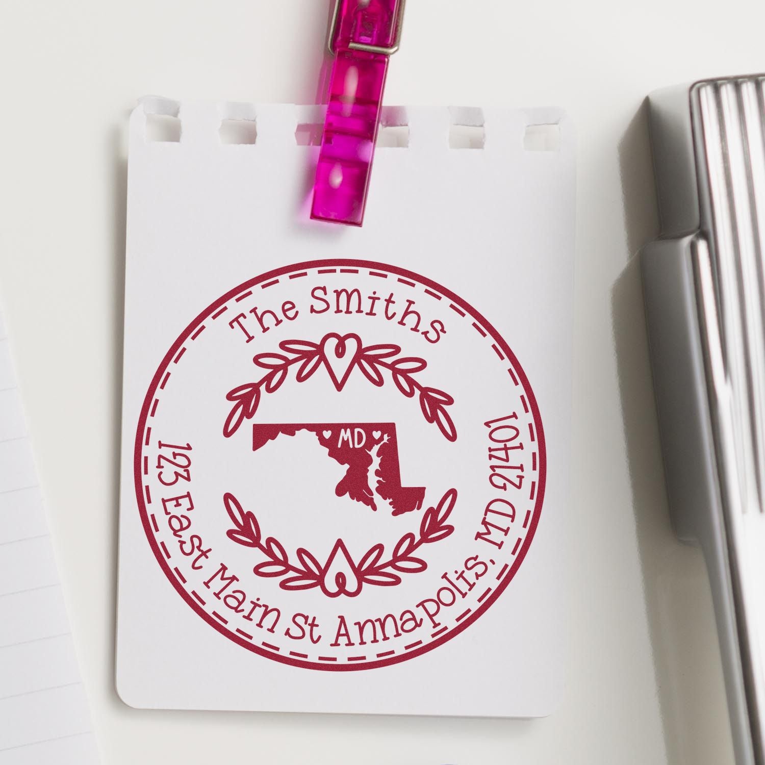 Burgundy custom stamp seal on white card with Maryland map, The Smiths, East Main St Annapolis, and a pink clip.