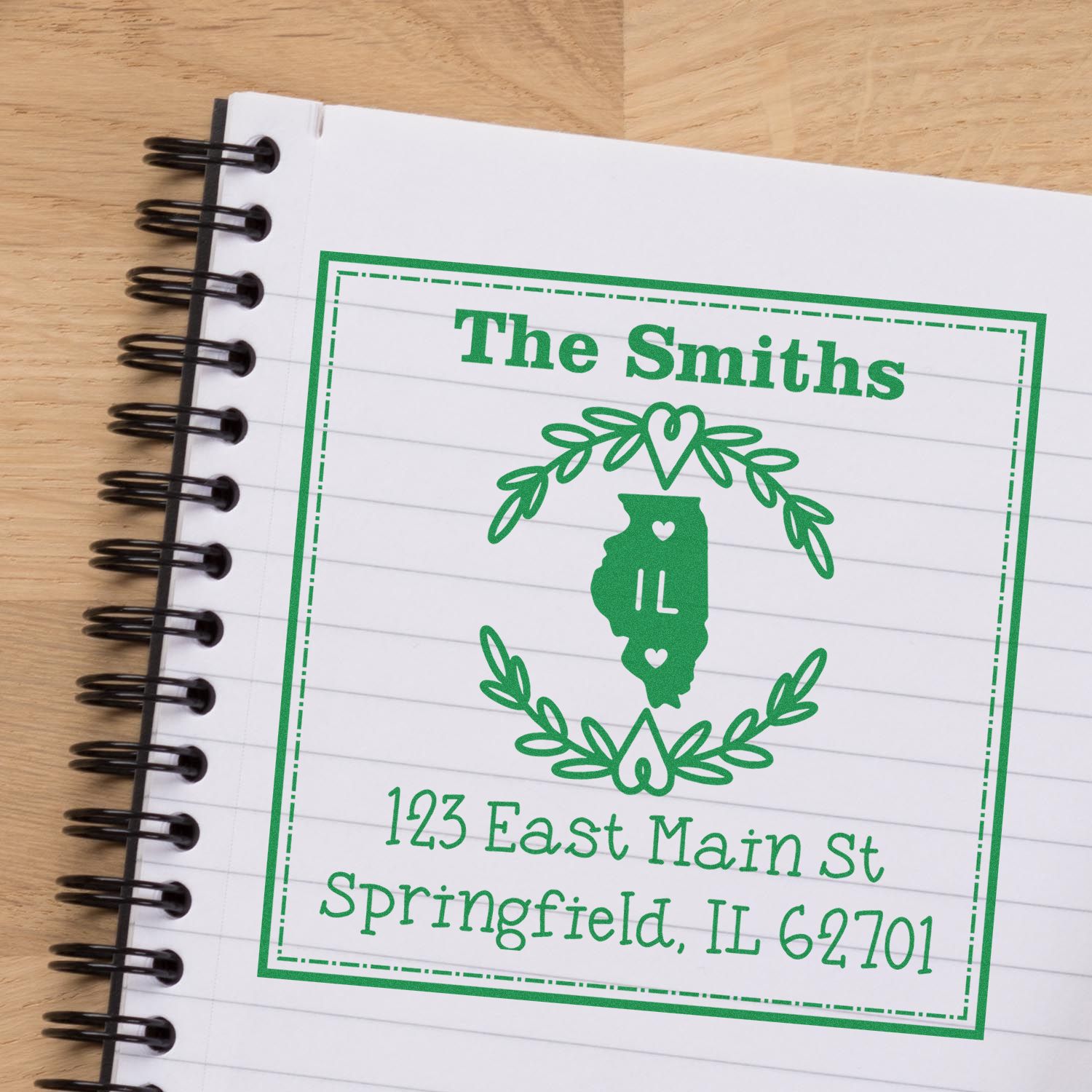 Green custom stamp and seal design with Illinois silhouette, wreath, and The Smiths return address on a notebook.