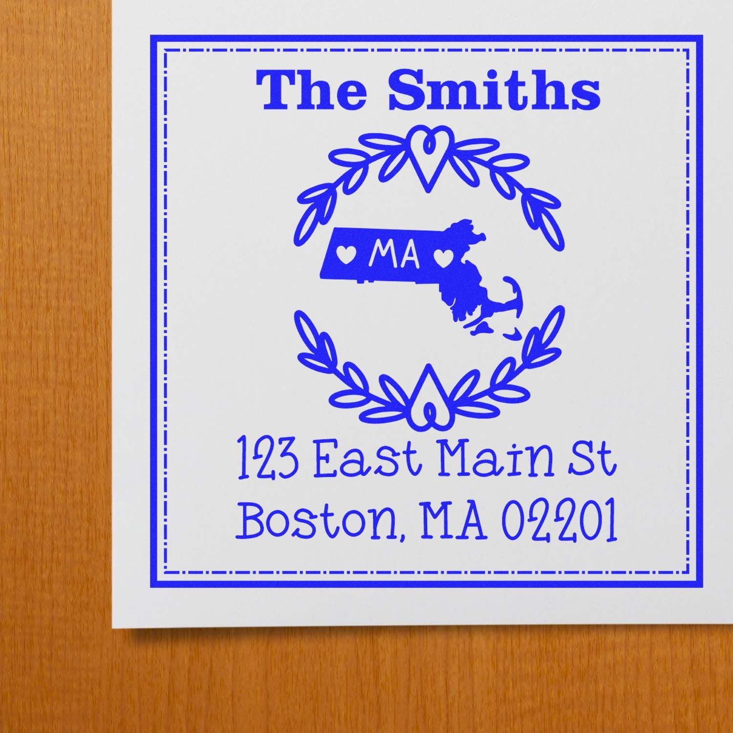 Blue custom address stamp with The Smiths, Massachusetts map seal, heart wreath, and Boston MA address on white.