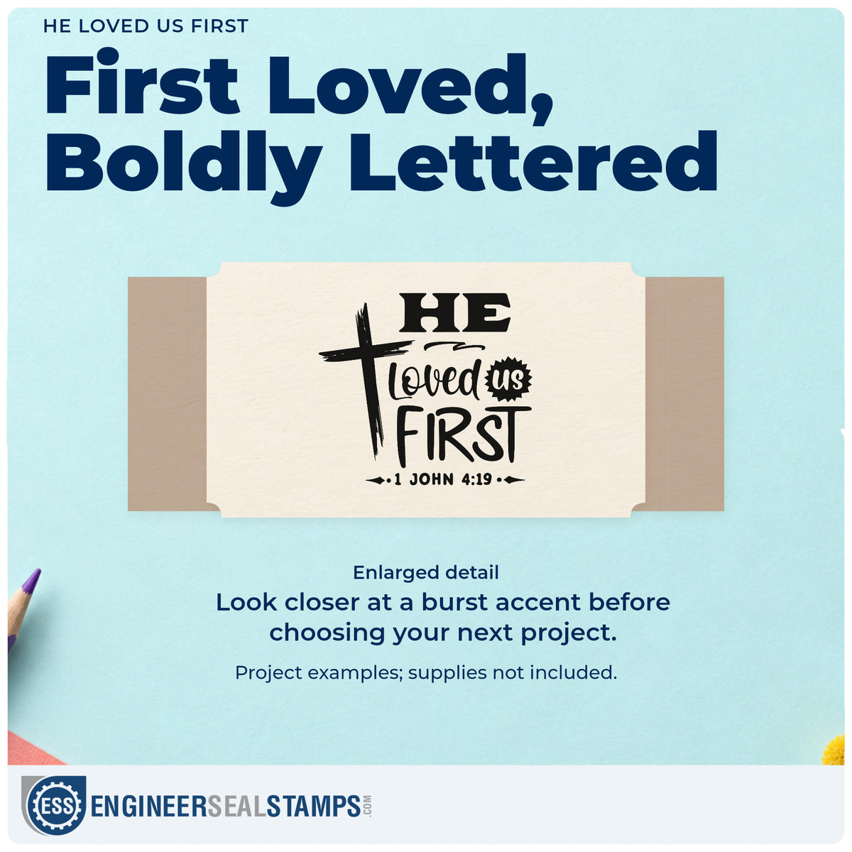 Enlarged detail of the He Loved Us First Hand Stamp – Duo imprint. A brushstroke cross stands beside "He loved us first," with "Us" in a small burst and 1 John 4:19 below.