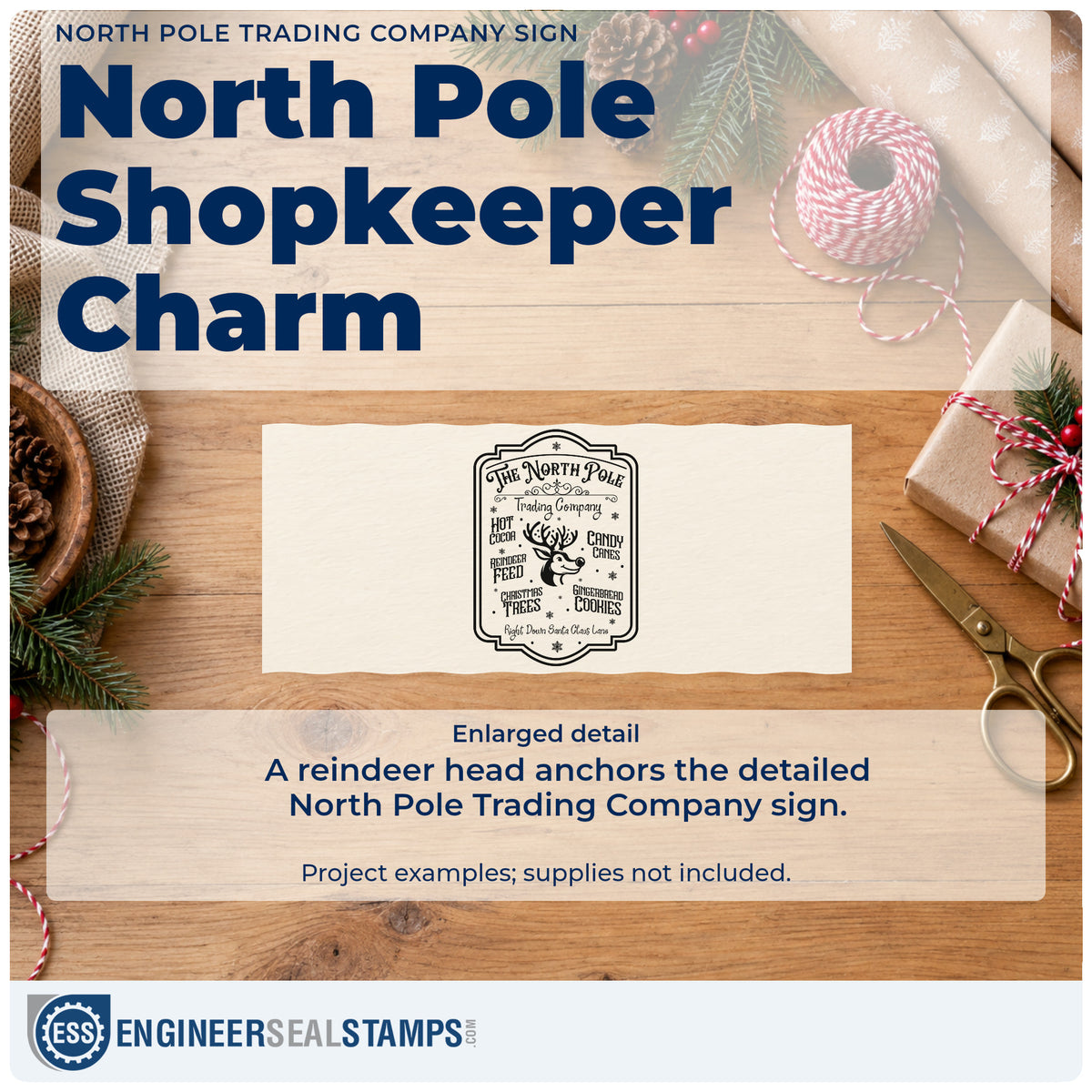 Enlarged detail of the North Pole Trading Company Sign Premium Wooden Stamp – Vintage Pro imprint. A bordered North Pole Trading Company sign features a reindeer head surrounded by hot cocoa, candy canes, reindeer feed, trees, and cookie wording.