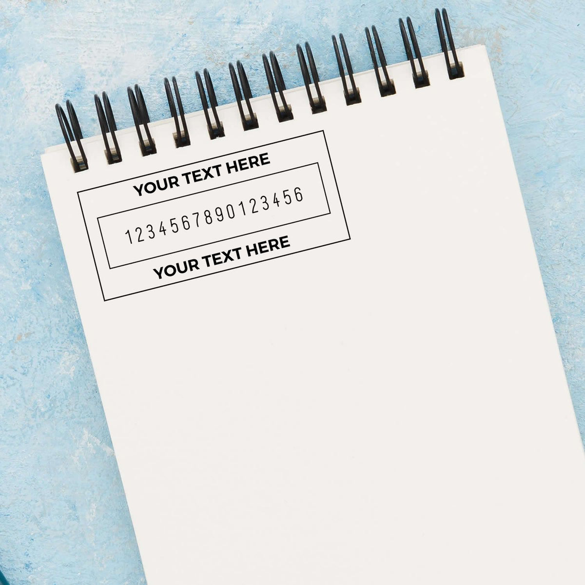 White spiral notebook on blue textured background with custom stamp and seal template, black placeholder text and numbers.