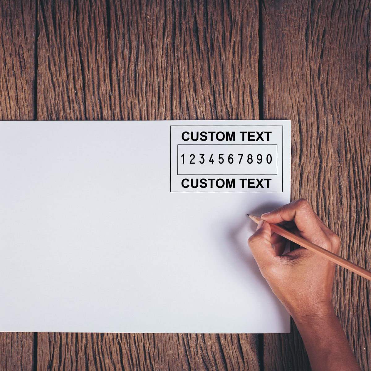 Custom stamp and seal template on white paper with black text, over rustic brown wood, hand holding a pencil.
