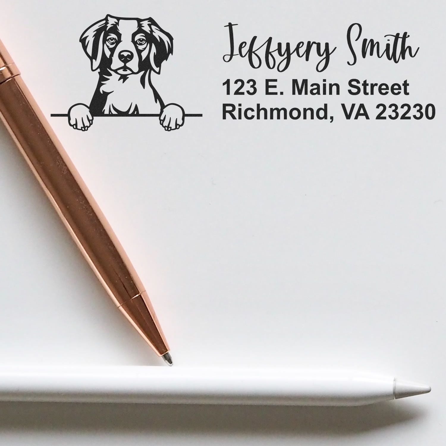 Custom black dog address stamp and seal with Jeffrey Smith, Richmond VA, on white paper beside a rose gold pen.