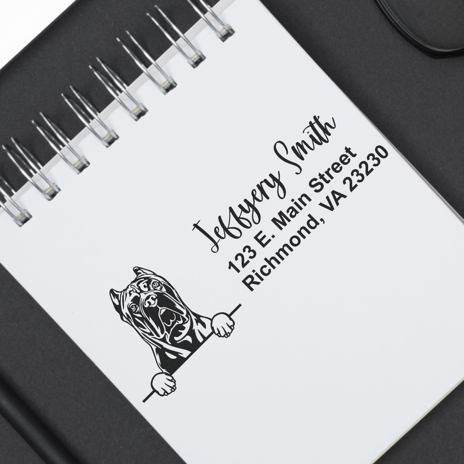 Black custom dog logo stamp and seal on white spiral notebook with Jefferson Smith address