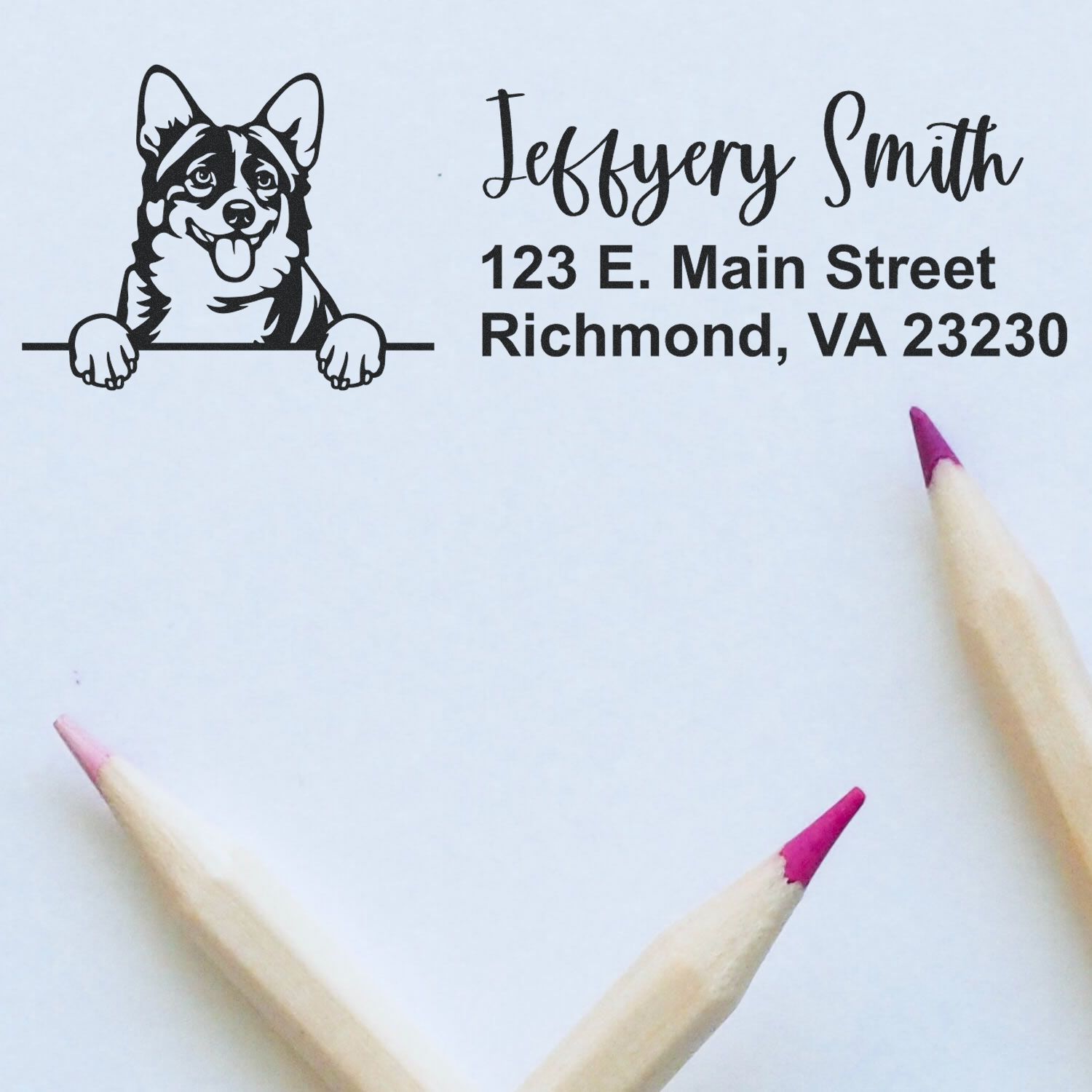 Custom stamp and seal with black corgi logo, Jeffrey Smith address, on white paper with pink pencil tips.