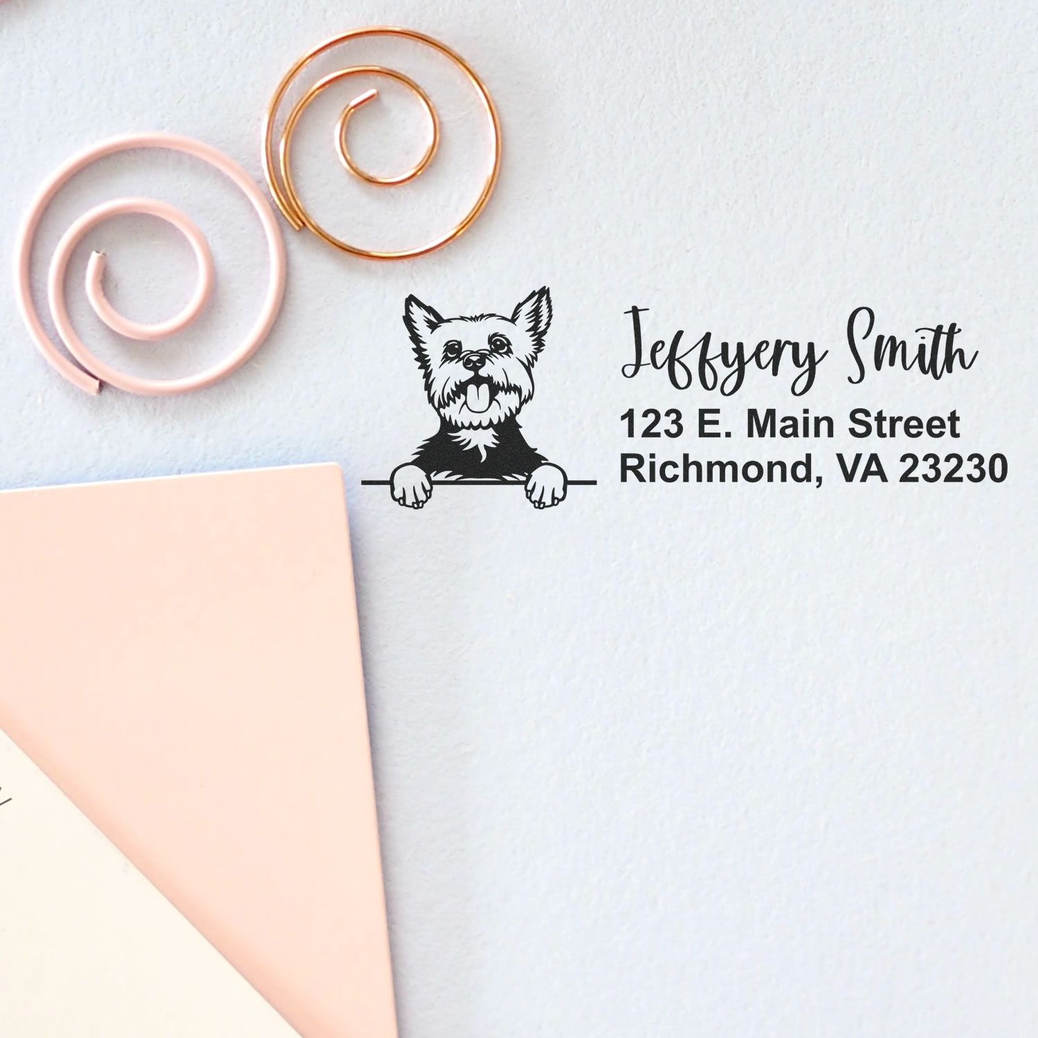 Custom address stamp with dog logo in black, plus pink and gold wax seal coils beside a blush envelope.