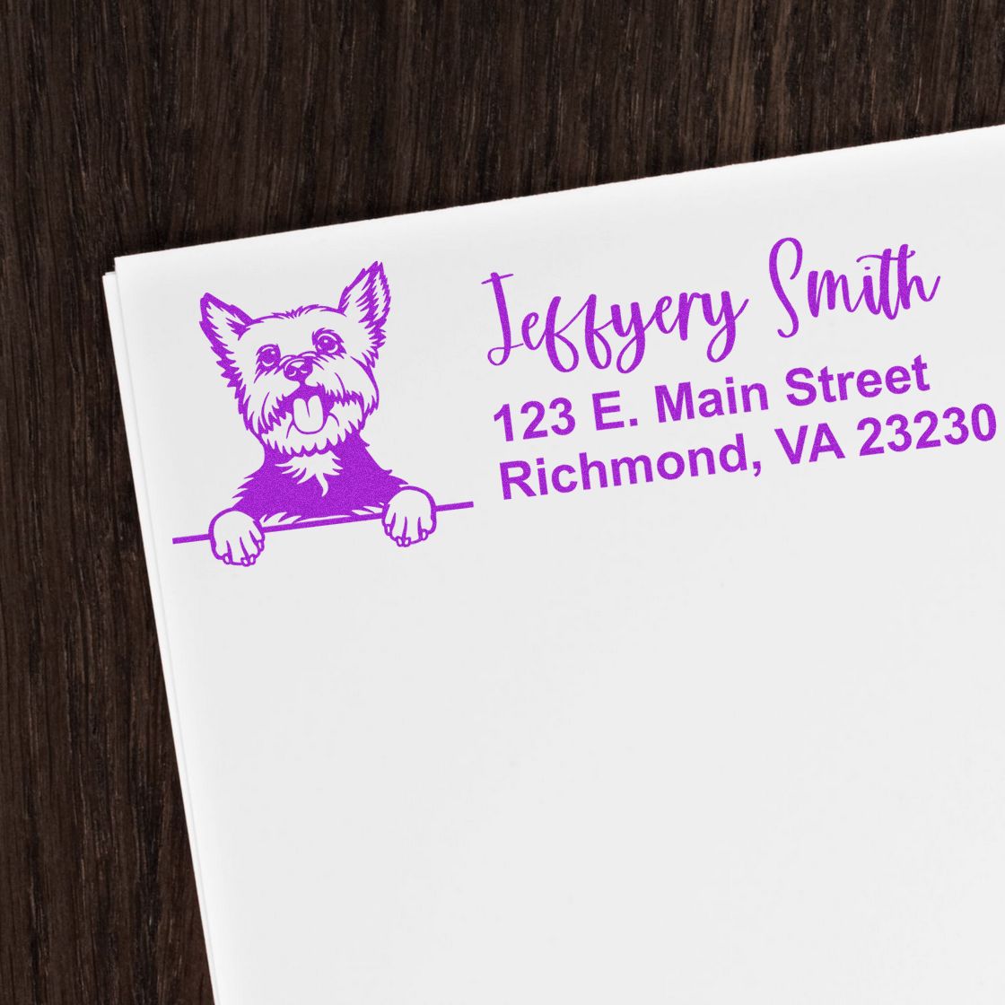 Purple custom dog return address stamp on white paper, with Jeffery Smith and Richmond, VA 23230 on dark wood.