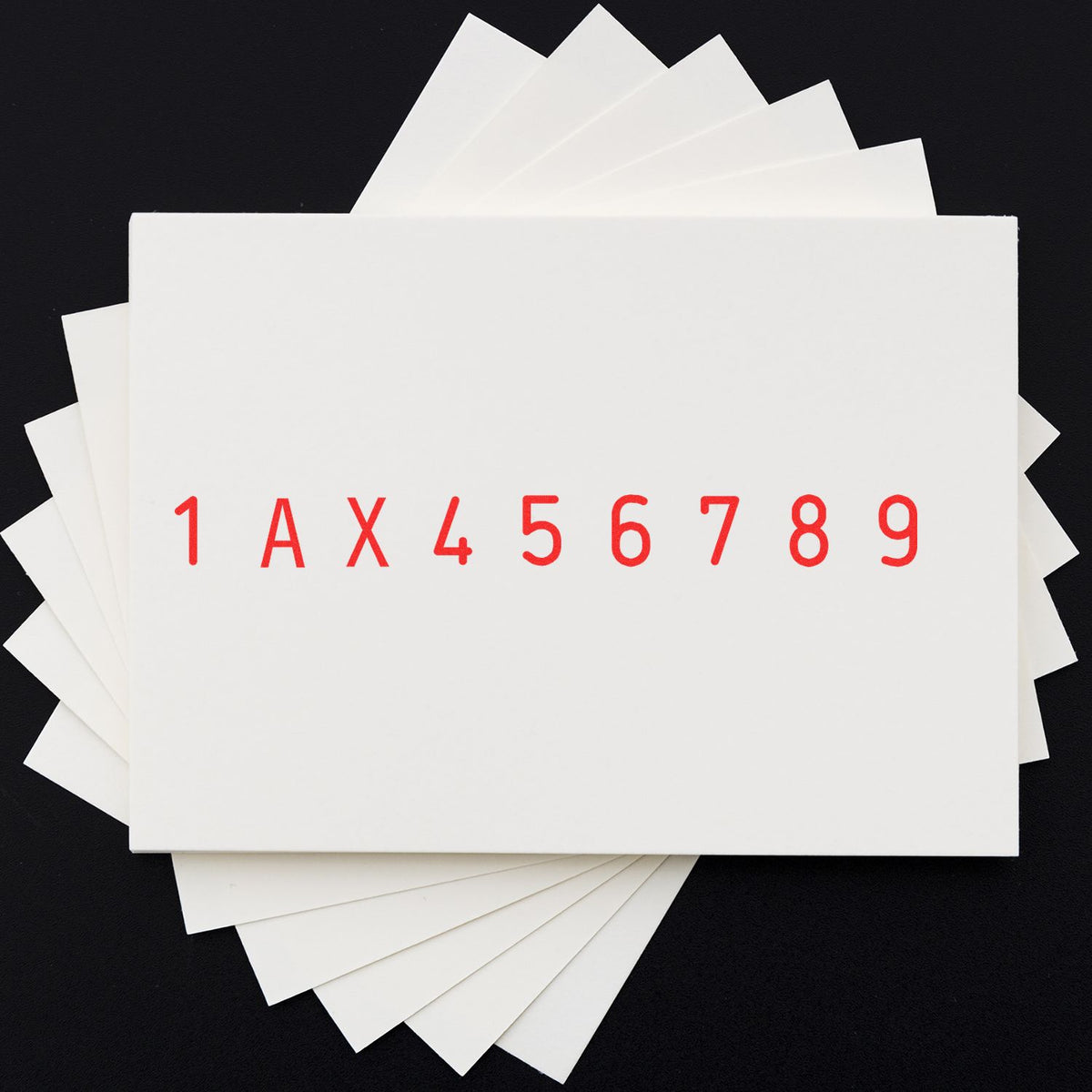 White stamp and seal sample sheets fanned on a black background, with red 1AX456789 lettering.