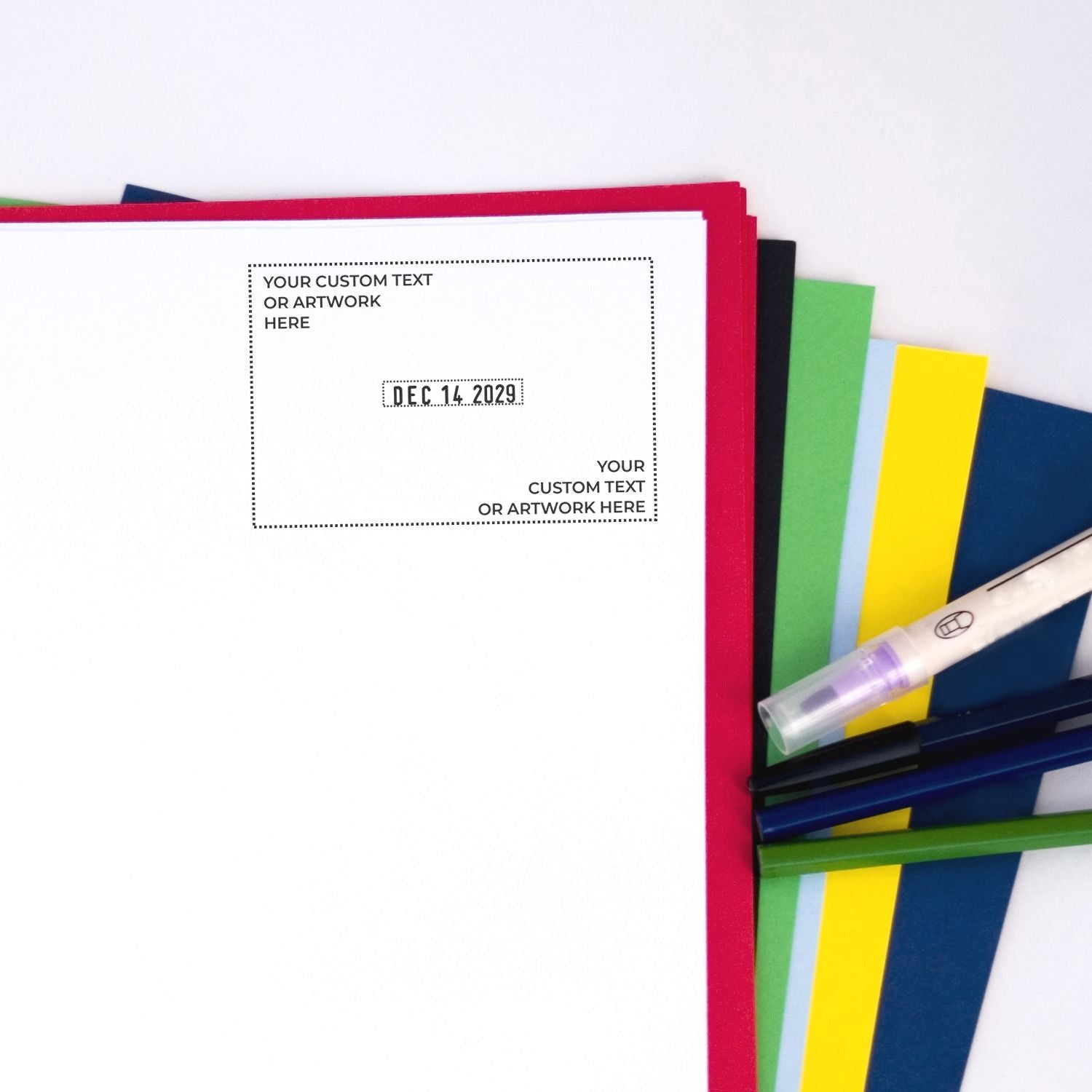 Custom stamp and seal set with white sheet, red border, dotted date seal, and colorful sample folders in green, yellow, blue.