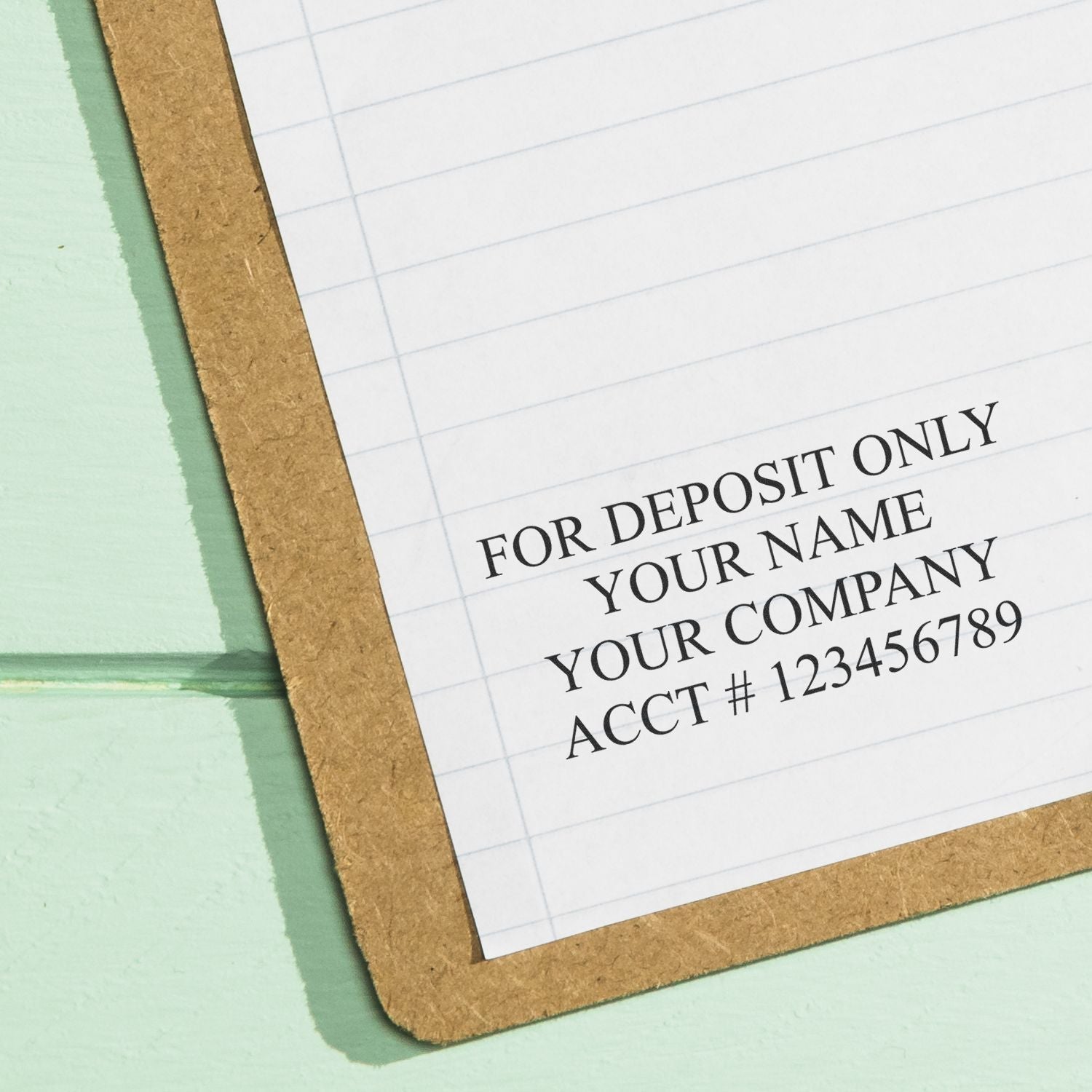4 Line Self Inking Check Endorsement Stamp used on a lined paper, showing text FOR DEPOSIT ONLY YOUR NAME YOUR COMPANY ACCT # 123456789 .