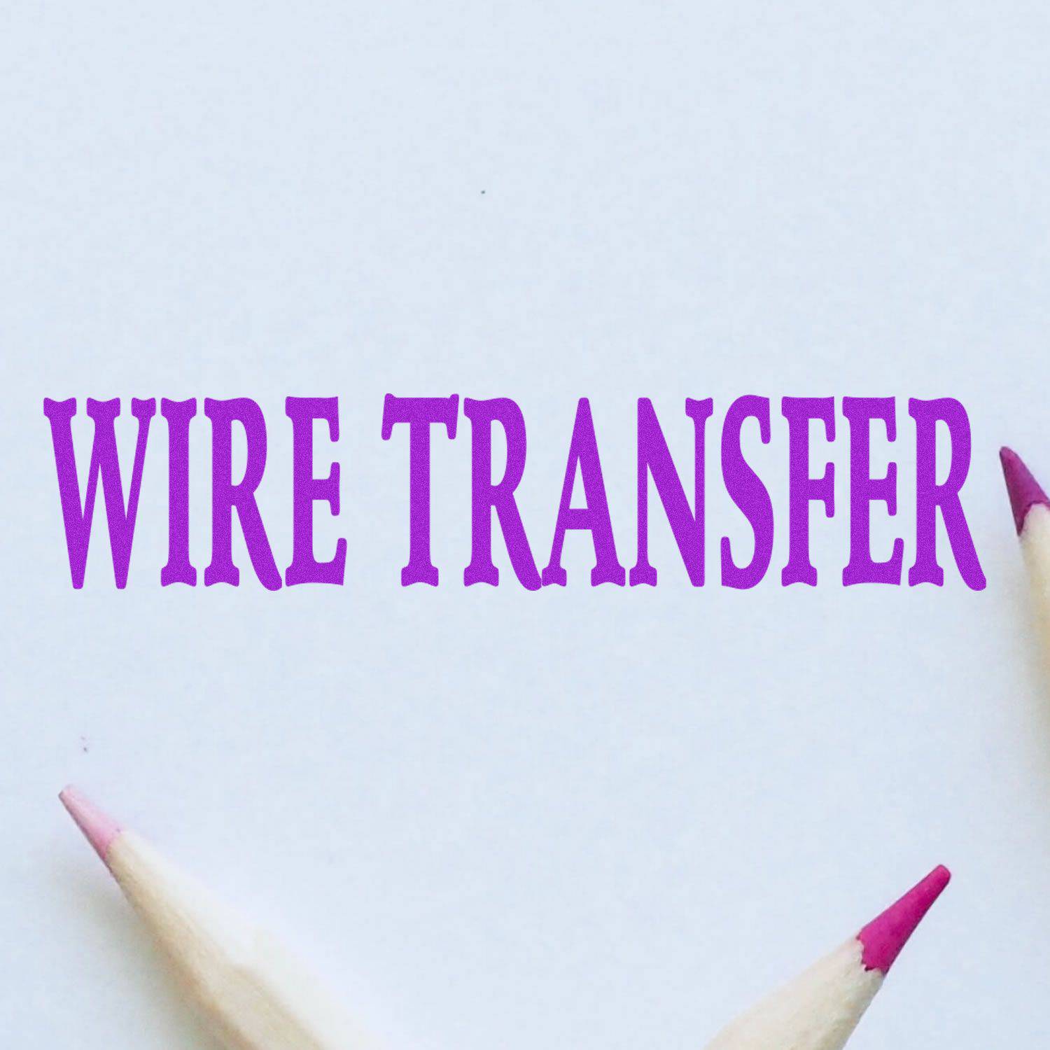 Large Pre-Inked Wire Transfer Stamp in purple ink on white paper, surrounded by three pencils with pink tips.