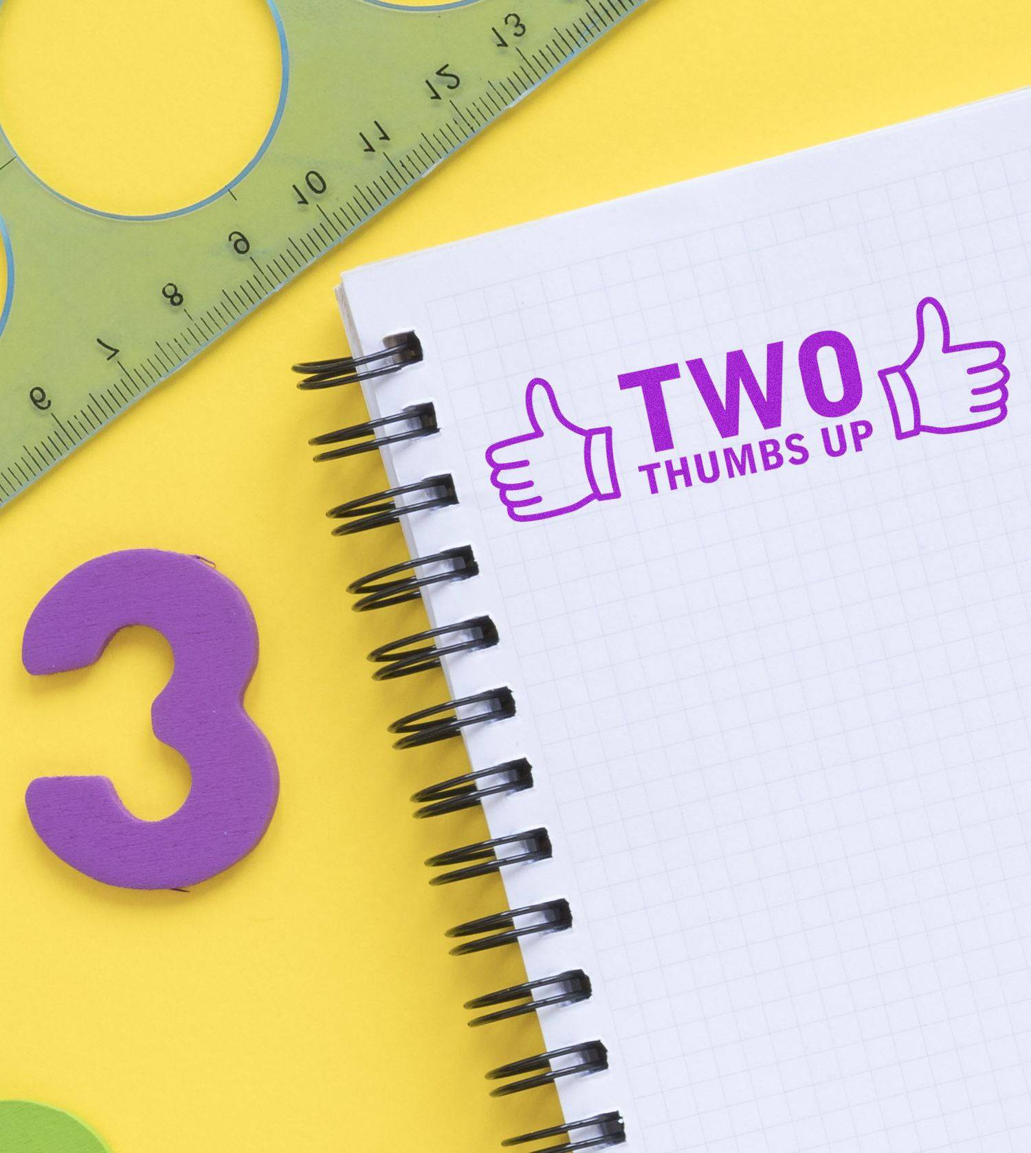 Large Pre-Inked Two Thumbs Up with Thumb Icon Stamp on a notebook, surrounded by a ruler, a purple number 3, and a yellow background.