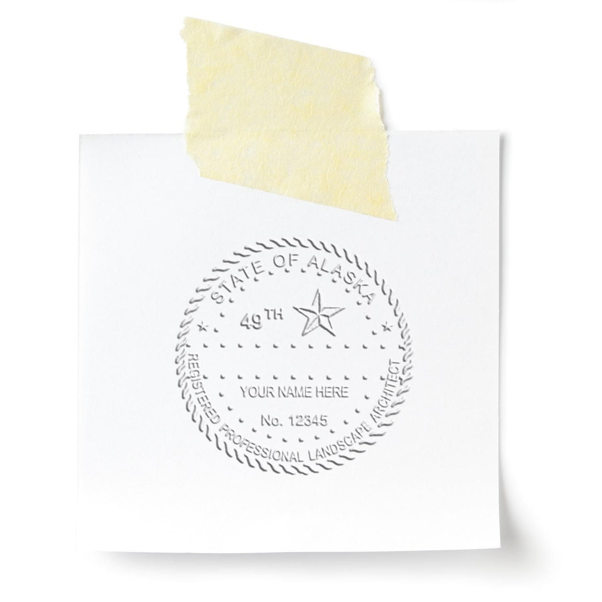 An in use photo of the Gift Alaska Landscape Architect Seal showing a sample imprint on a cardstock