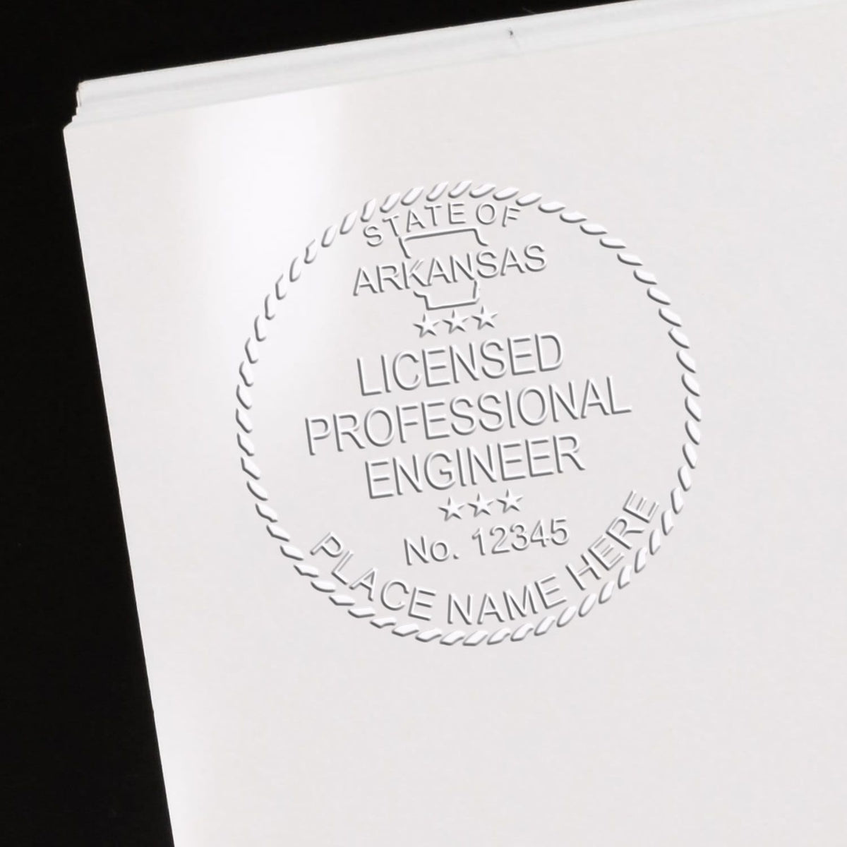 An alternative view of the Heavy Duty Cast Iron Arkansas Engineer Seal Embosser stamped on a sheet of paper showing the image in use