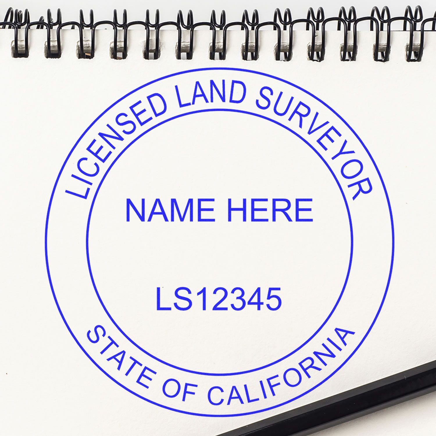 Premium MaxLight Pre-Inked California Surveyors Stamp on a white notepad with a spiral binding, featuring customizable text for licensed land surveyors.