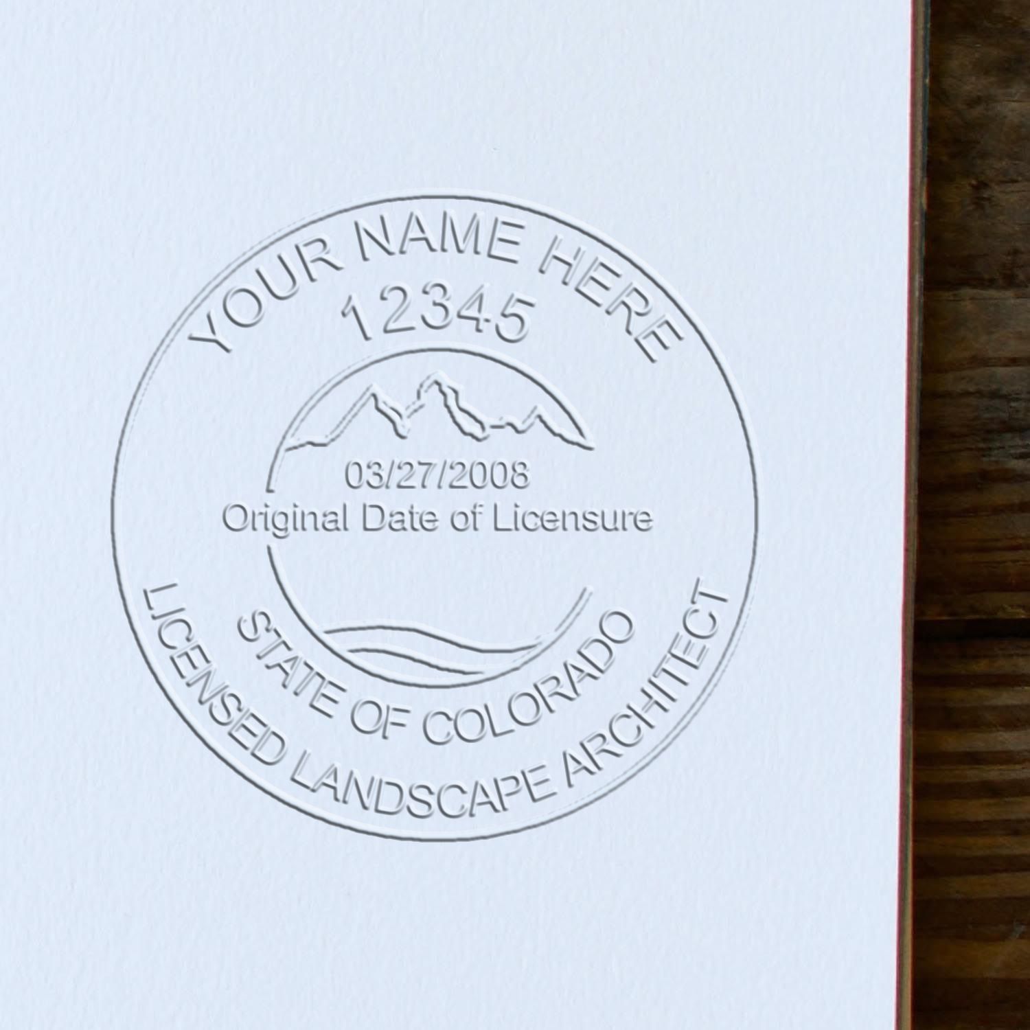 An in use photo of the Hybrid Colorado Landscape Architect Seal showing a sample imprint on a cardstock