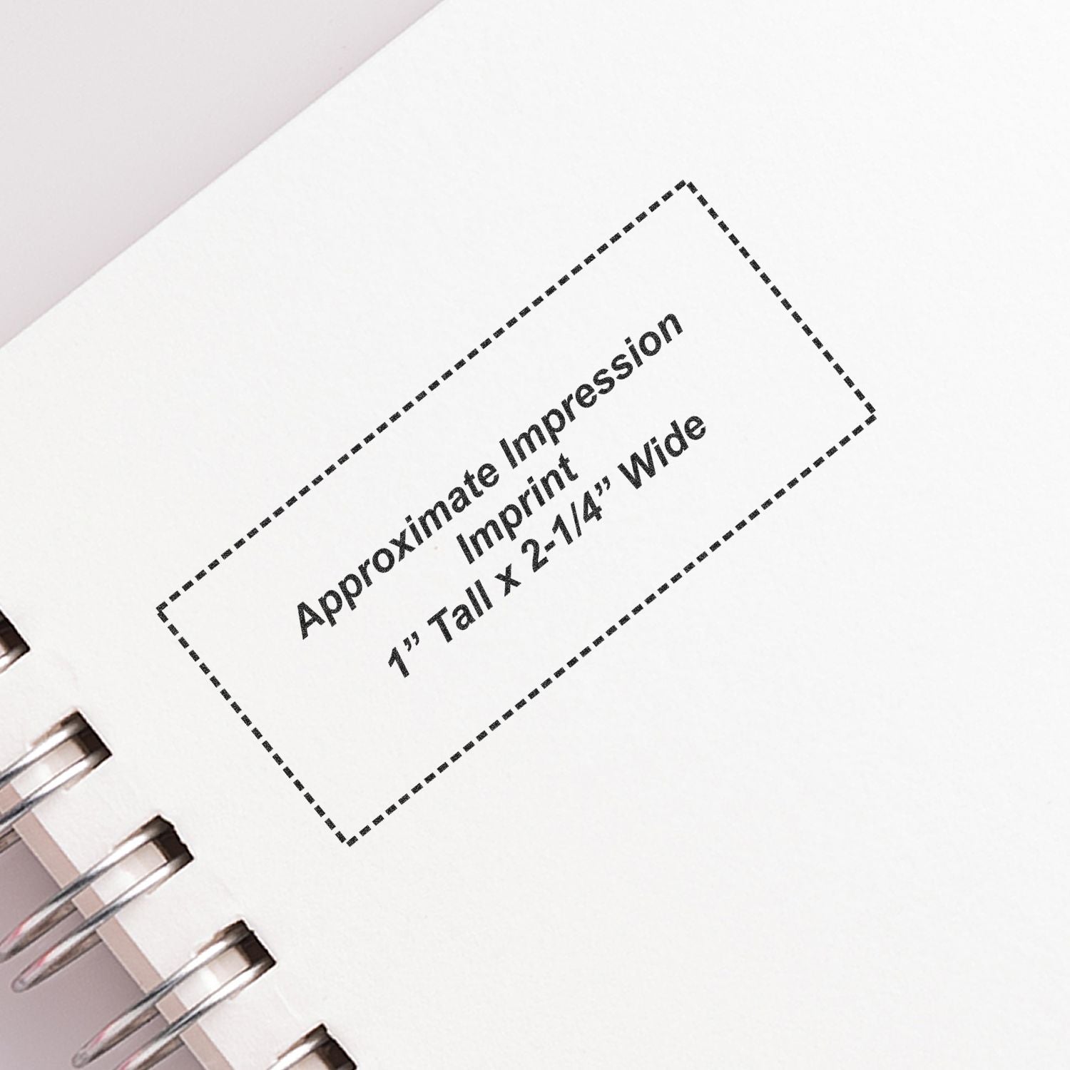 Custom Self Inking Stamp Trodat 5204 Size 1 x 2-1/4 imprint on a white notebook page with spiral binding.