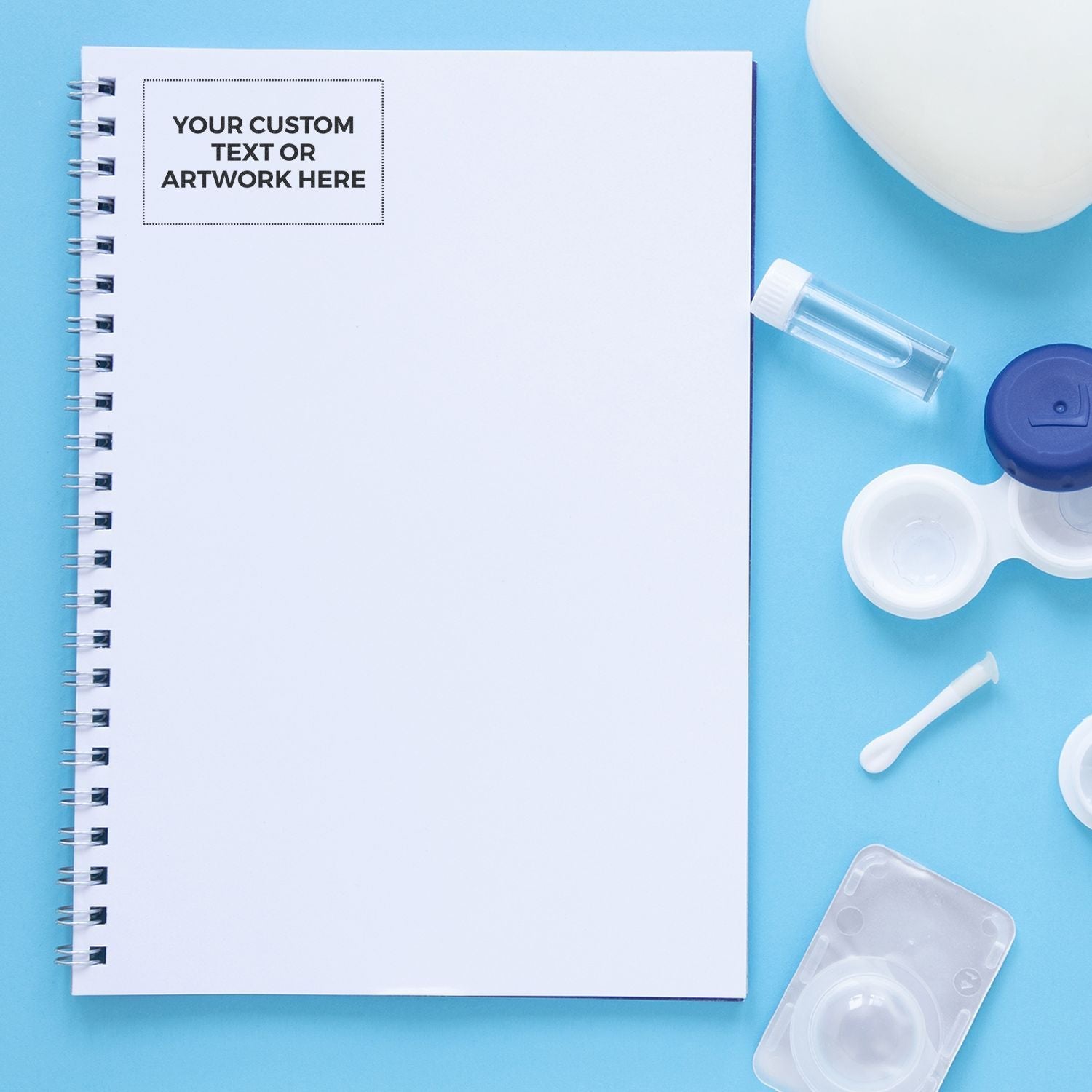 Custom Self Inking Stamp Trodat 5212 Size 2-3/4 x 4-1/2 on a blue background with a notebook, contact lens case, and other small items.