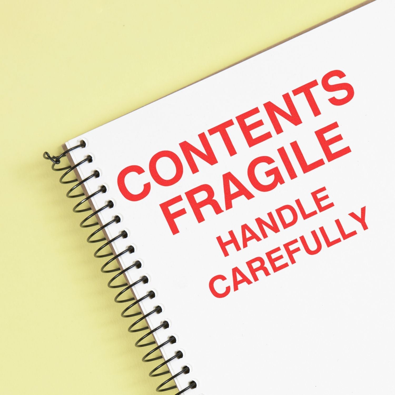 MaxLight XL2-700 Custom Pre-Inked Business Stamp 2-3/4-x 3-3/4 used to stamp CONTENTS FRAGILE HANDLE CAREFULLY on a spiral notebook.