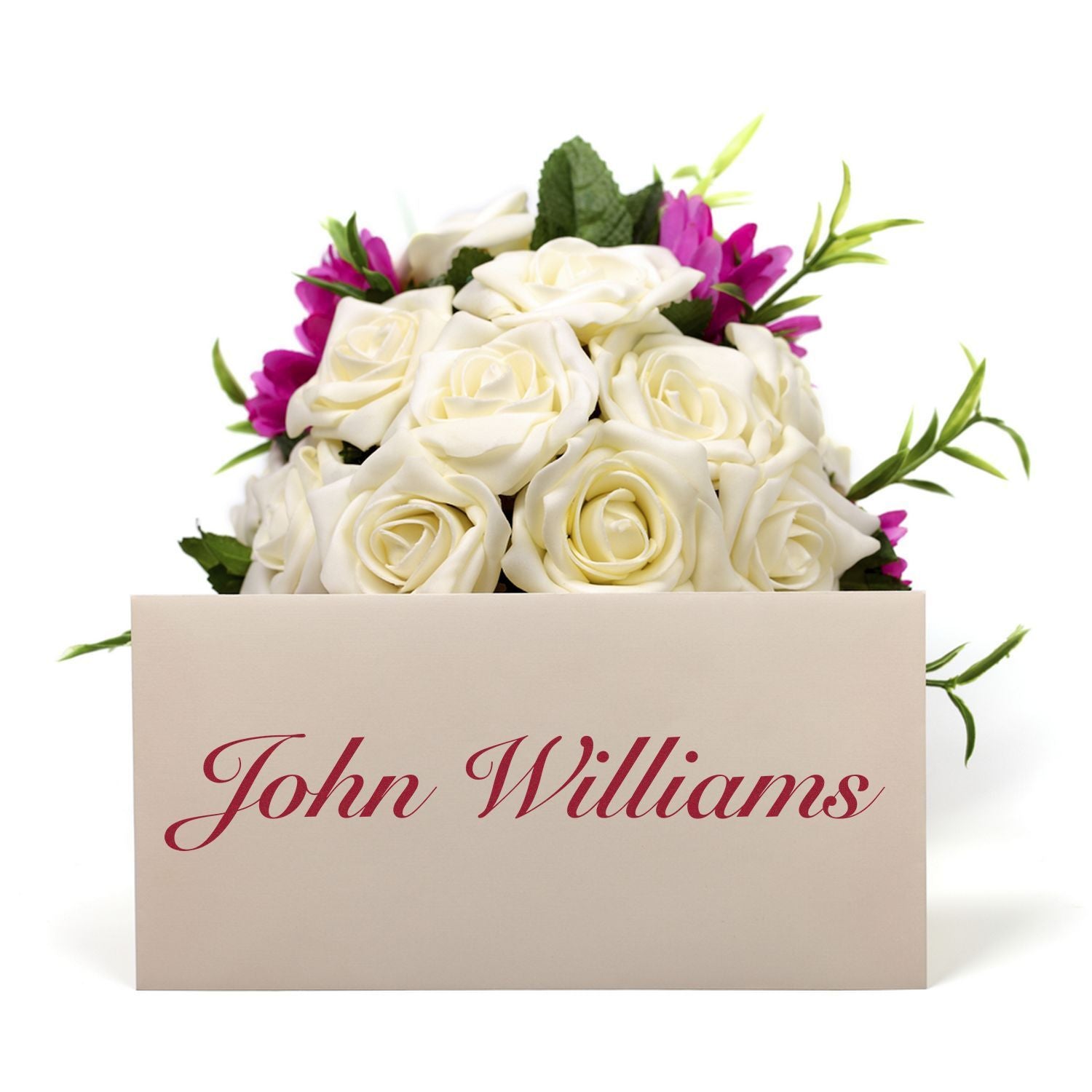 A Custom Self Inking Stamp Trodat 4925 Size 1 x 3-1/4 is used to stamp John Williams on a card placed in front of a bouquet of white and purple flowers.