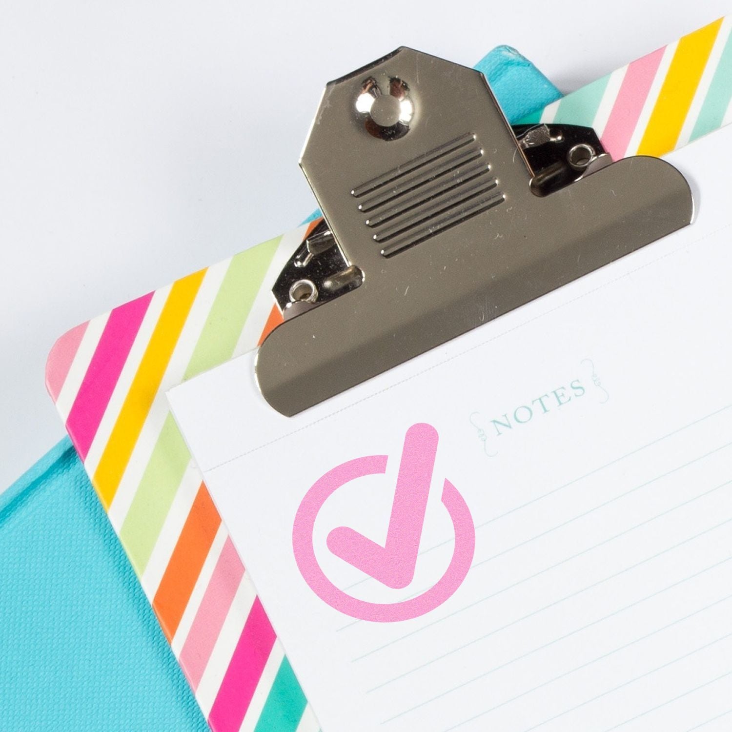 Clipboard with a colorful striped cover and a paper stamped with a pink checkmark using the Custom Rubber Stamp Size 2 Inch Diameter.
