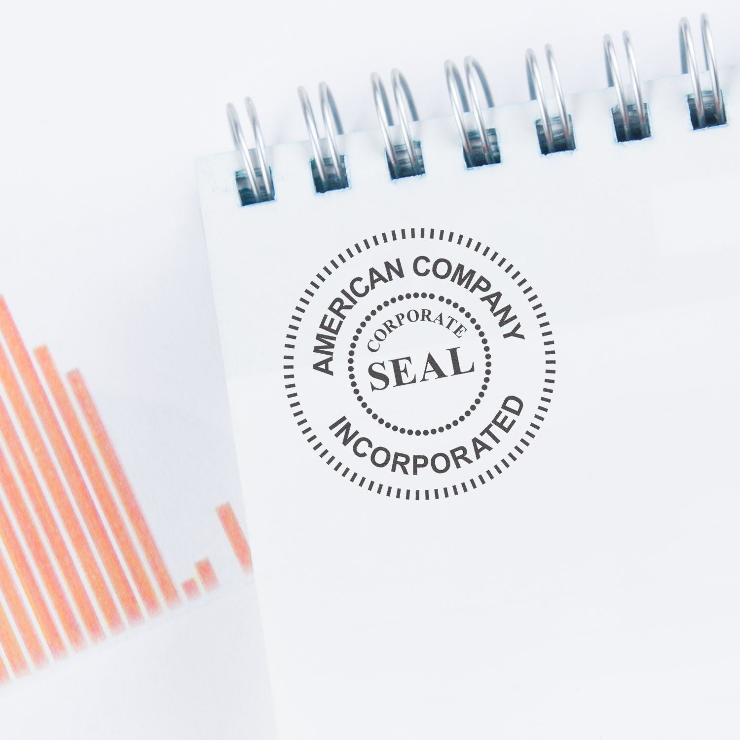 Custom Self Inking Stamp Trodat 4638 Size 1-1/2 Diameter used on a white notepad with a spiral binding and a partial orange graph.