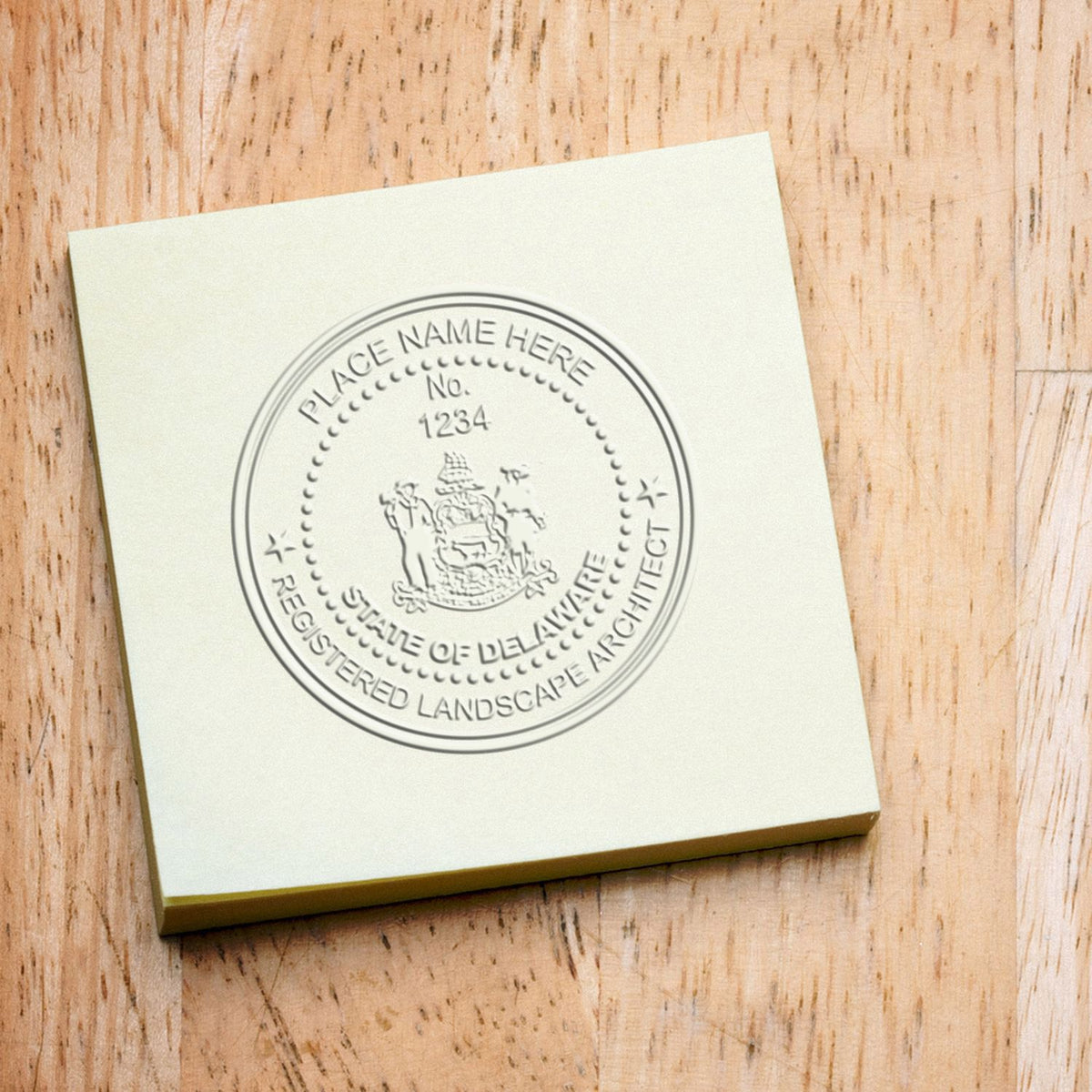 A lifestyle photo showing a stamped image of the Soft Pocket Delaware Landscape Architect Embosser on a piece of paper