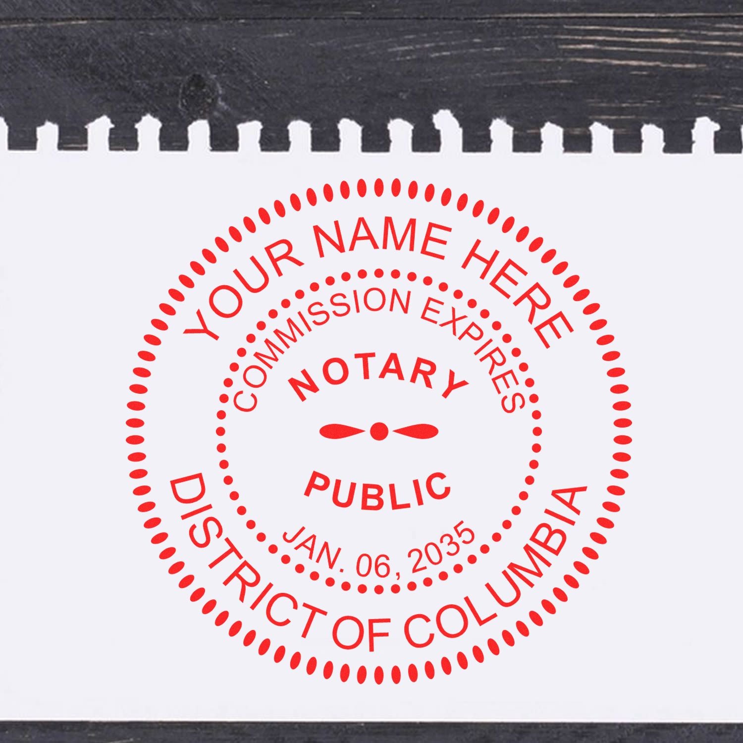 An alternative view of the Official Self-Inking District of Columbia Notary Stamp stamped on a sheet of paper showing the image in use