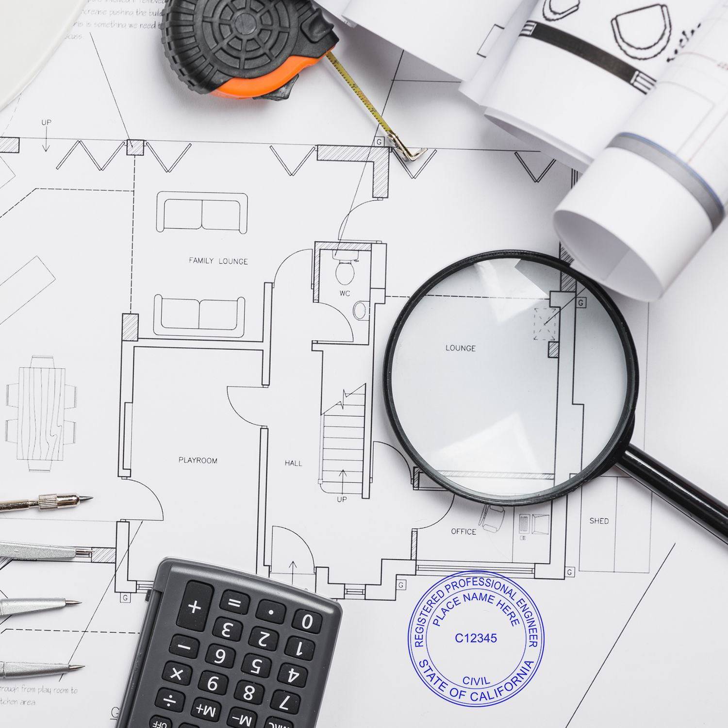 Blueprint with a Self Inking Engineer Stamp of Seal, calculator, magnifying glass, tape measure, and drafting tools on a desk.