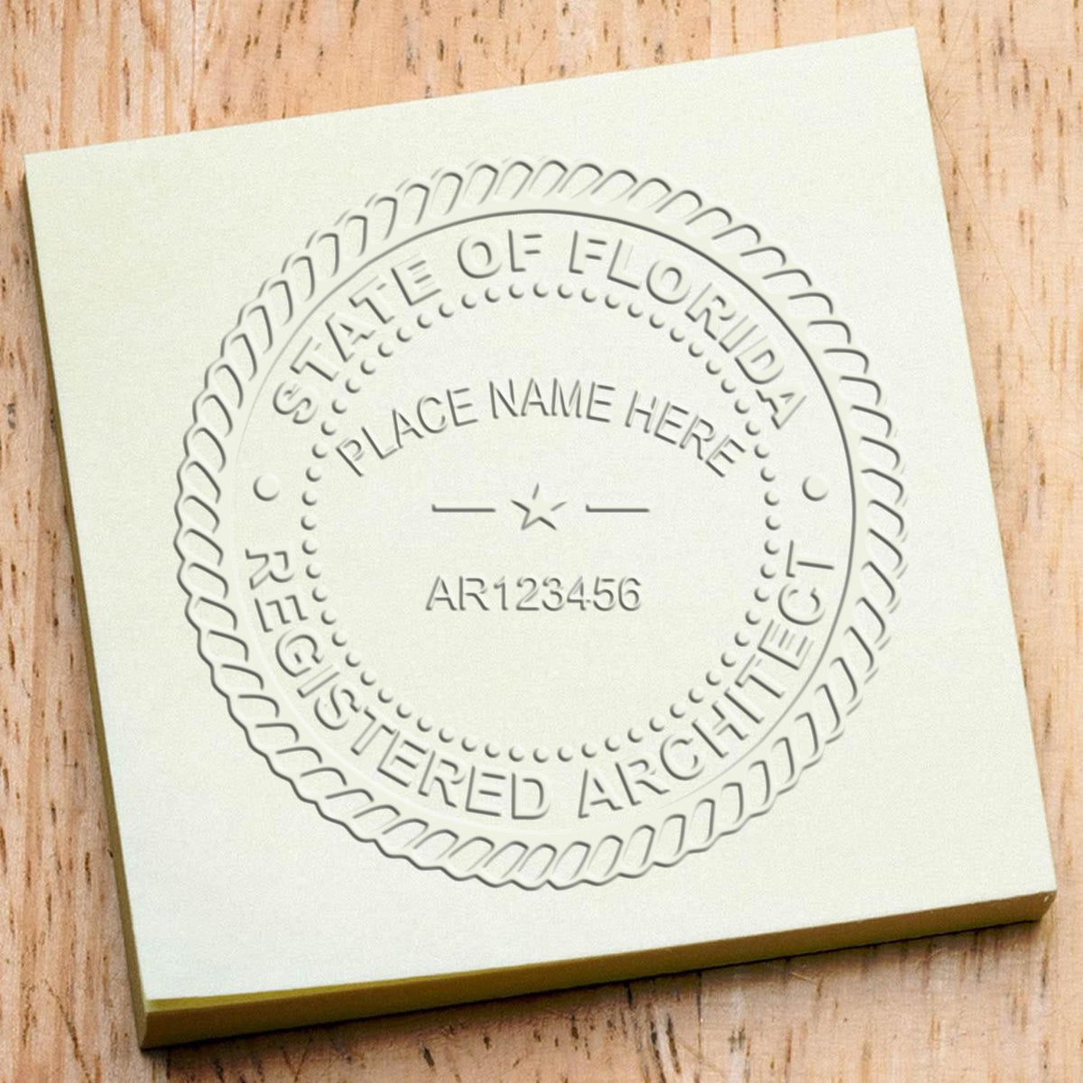 An in use photo of the Hybrid Florida Architect Seal showing a sample imprint on a cardstock