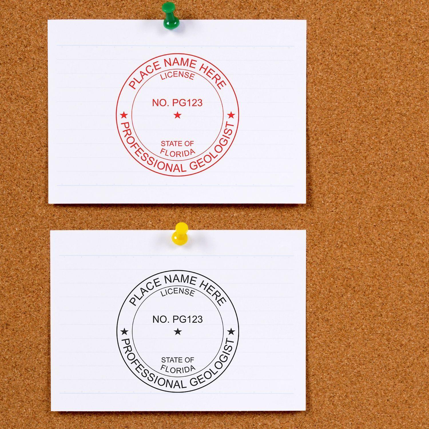 Two index cards on a corkboard, each stamped with the Geologist Slim Pre-Inked Rubber Stamp of Seal in red and black ink.