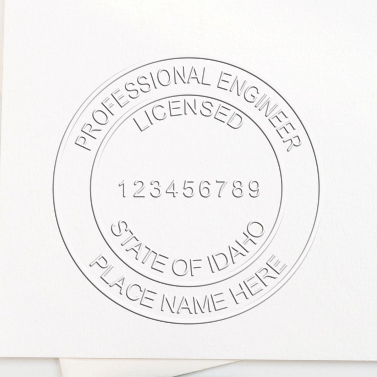 A lifestyle photo showing a stamped image of the Handheld Idaho Professional Engineer Embosser on a piece of paper