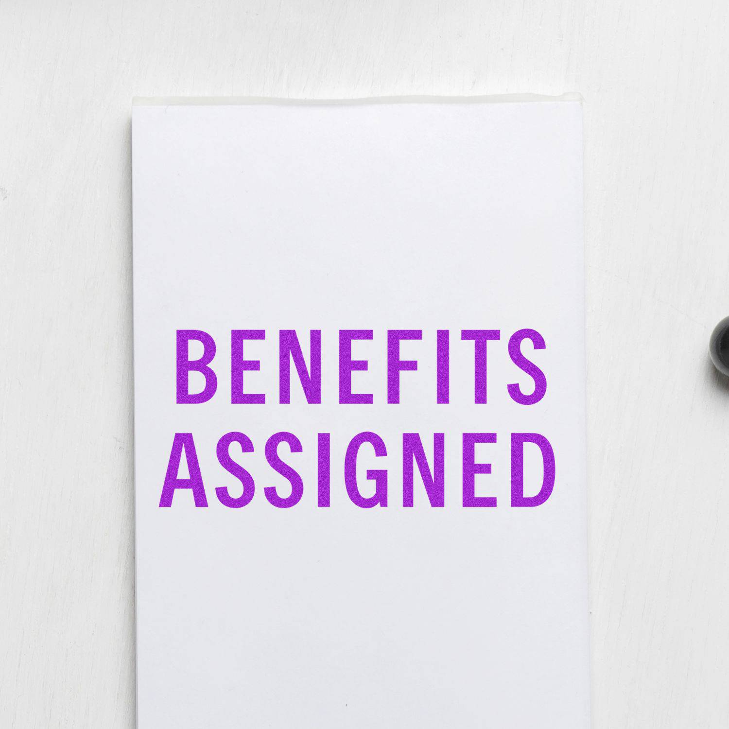 Large Self Inking Benefits Assigned Stamp in use, displaying the text BENEFITS ASSIGNED in bold purple on a white paper.