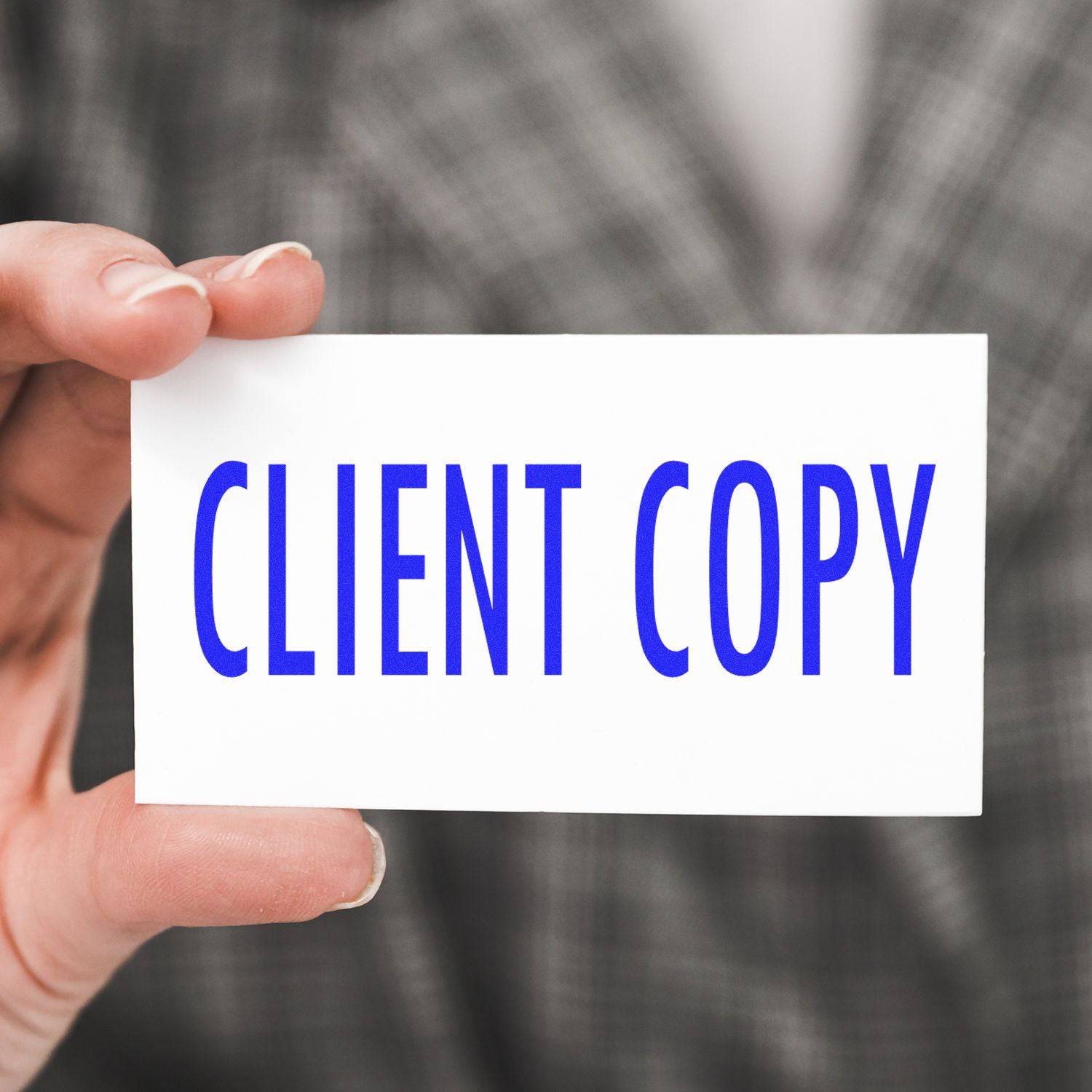 Hand holding a card stamped with CLIENT COPY in blue ink using the Large Self Inking Client Copy Stamp, with a blurred background.