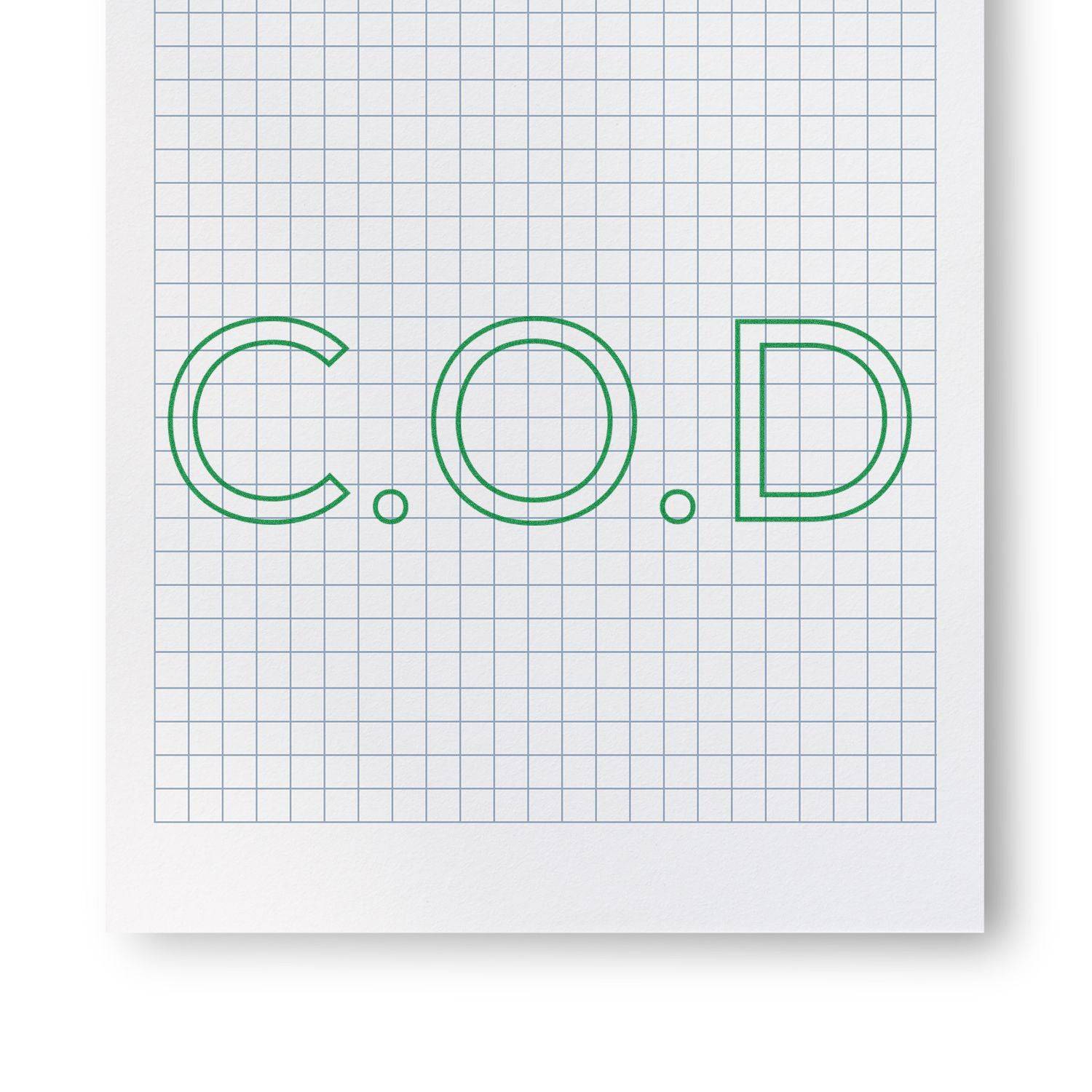 Large Pre-Inked COD Outline Stamp in use, creating a green C.O.D outline on a grid paper background.