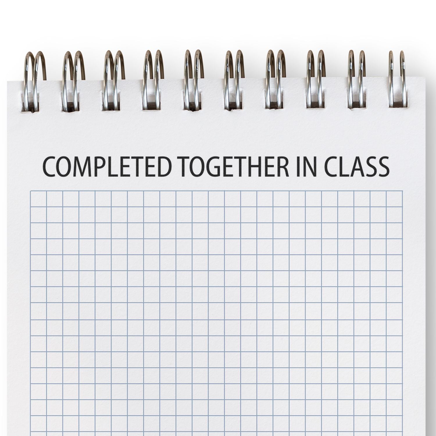 Slim Pre-Inked Completed Together In Class Stamp used on a spiral notebook with a grid pattern.